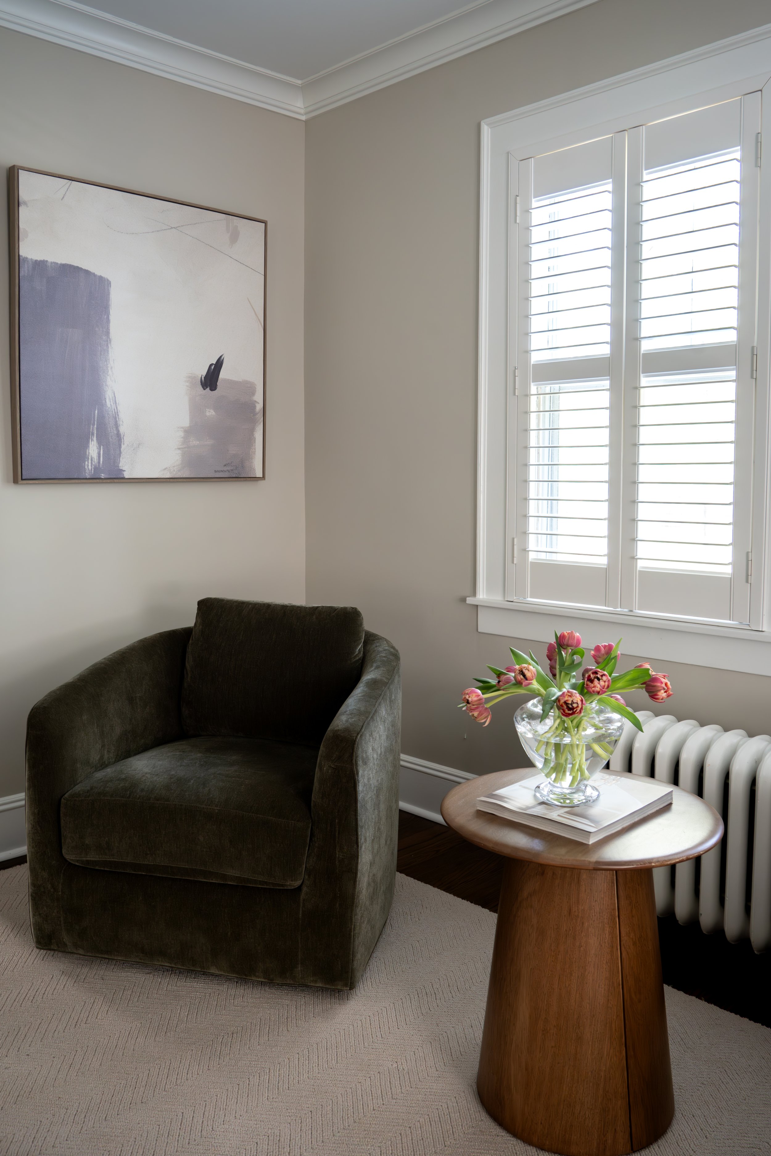 Cozy living room with dark sofa, layered rug, and natural wood side table — LR Studio home design