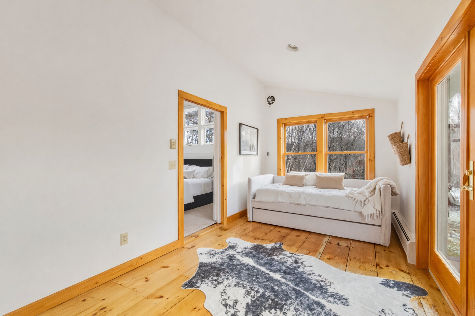 Cozy living room with layered textures, patterned rug, and double French doors — LR Studio interior styling Connecticut