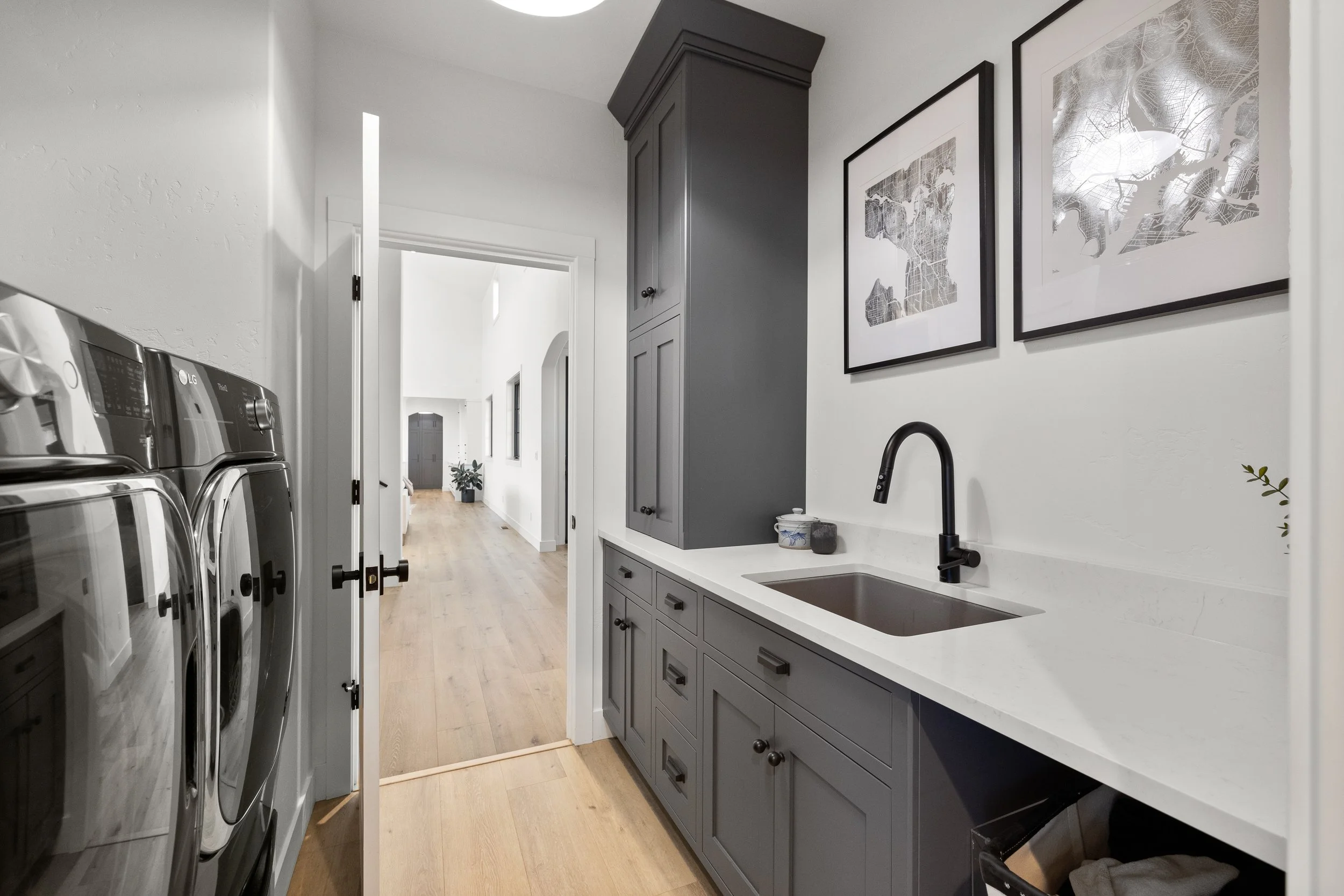 Modern grey bathroom with dark cabinetry, black fixtures, and framed mirror — LR Studio interior design