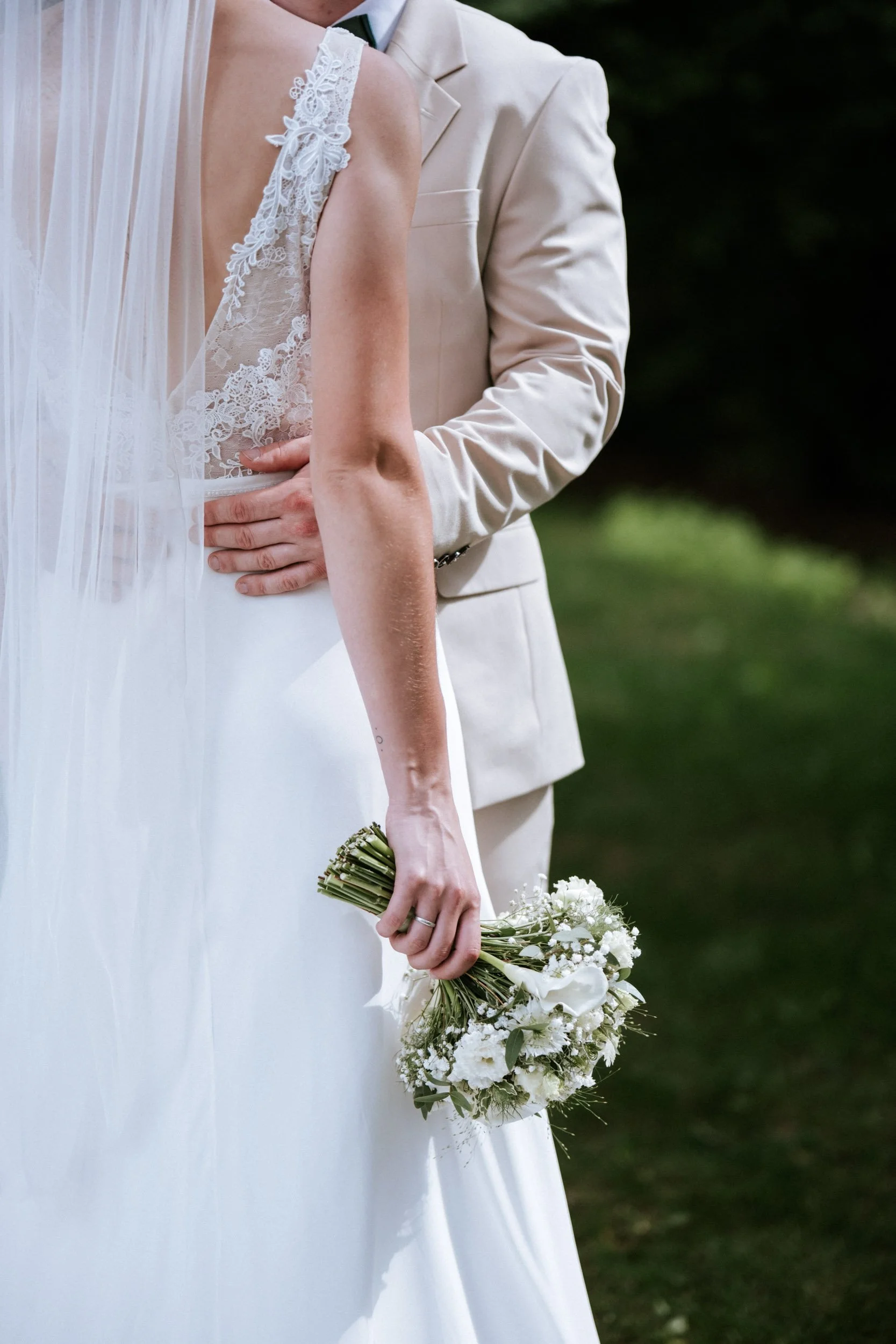 Detailaufnahme von Spitzen-Brautkleid, Schleier und weißem Brautstrauß bei einer Hochzeit in Wien
