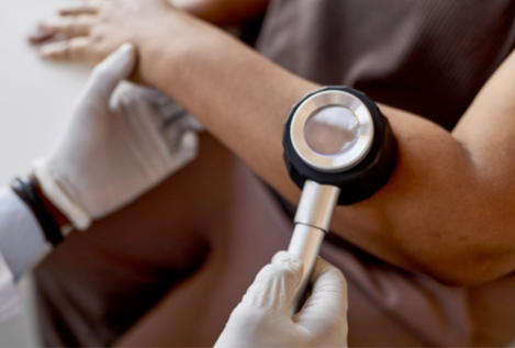A dermatoscope on a patient's arm