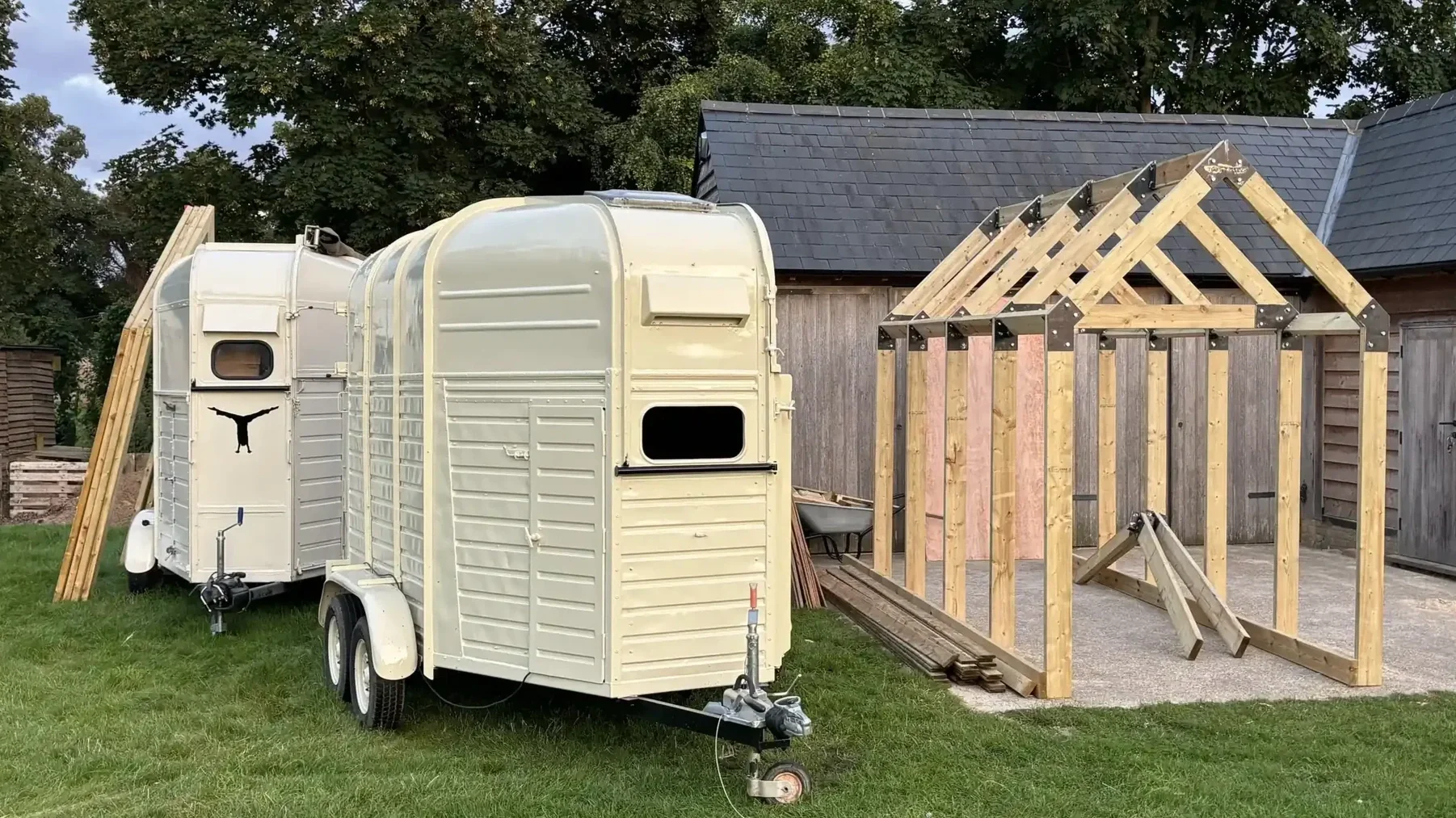 Tom's Trunks branded horsebox alongside bespoke timber frame structure being built from scratch at outdoor event venue