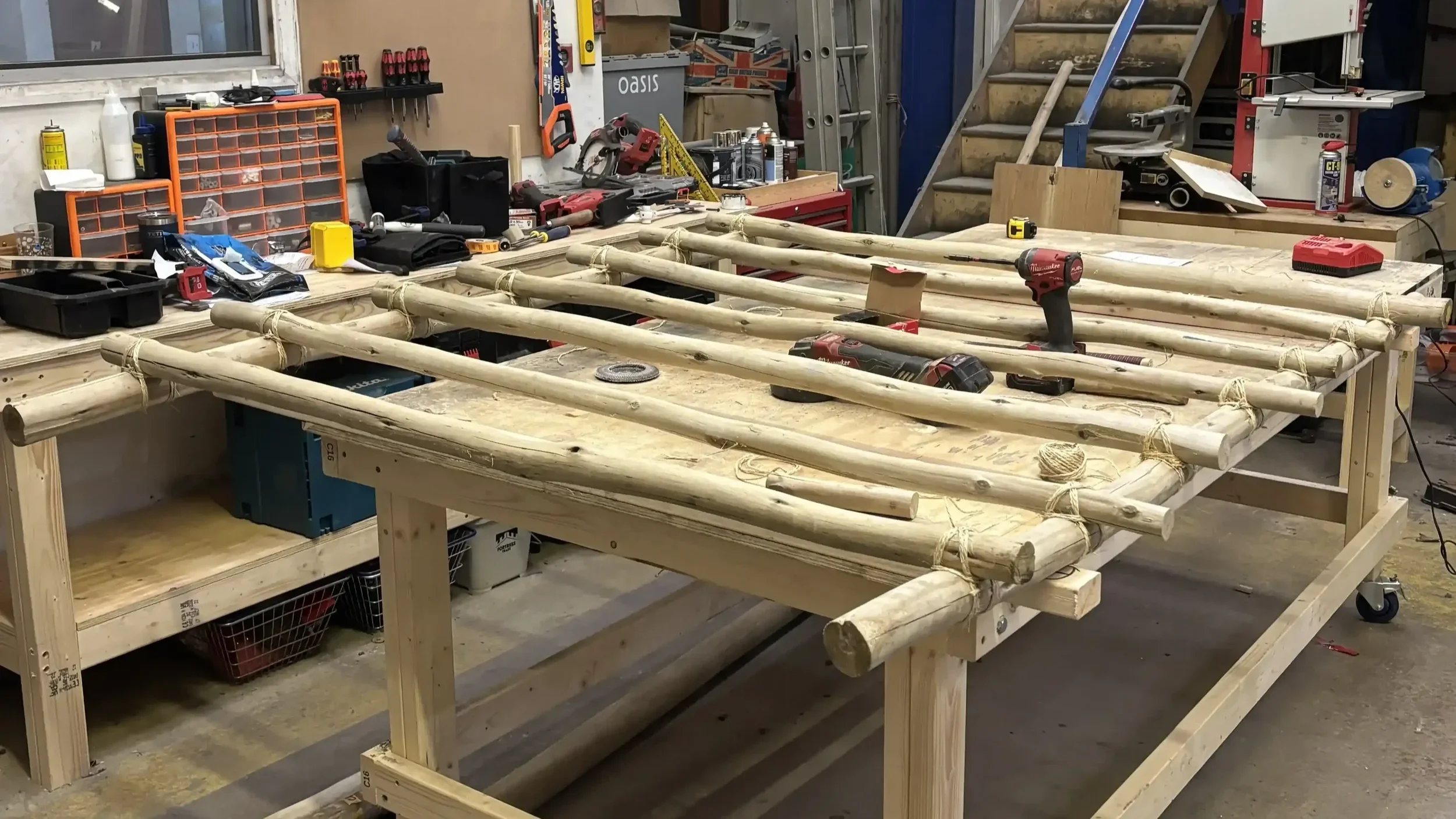 Bespoke large-scale timber frame under construction on rolling workbench in professional fabrication workshop for event build