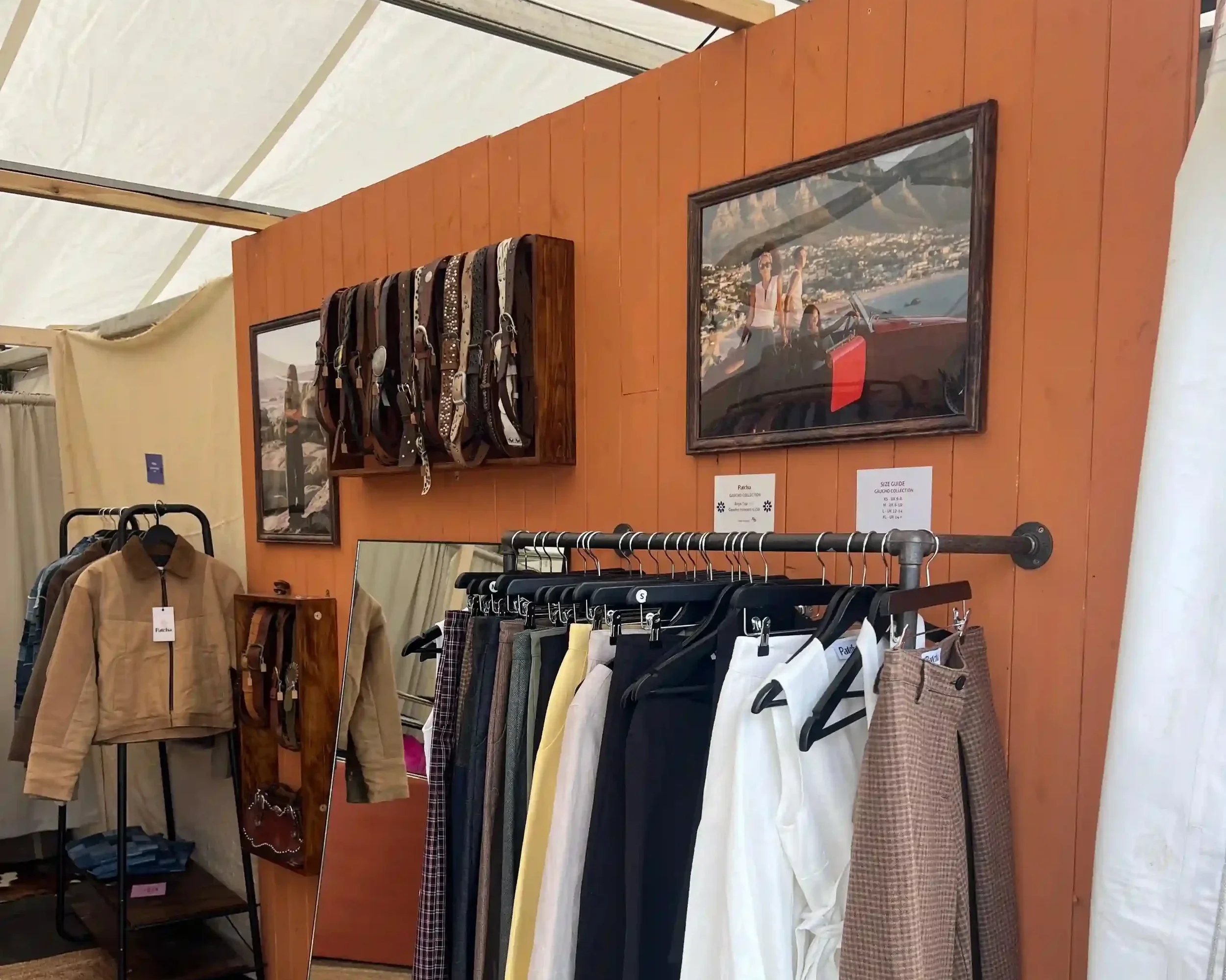 Patcha London bespoke event stand interior with clothing rack against terracotta wood-panelled wall inside a festival marquee