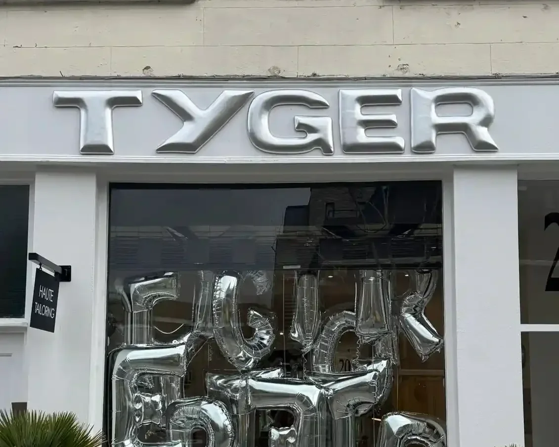 Tyger pop-up store brand activation with silver foil balloon window display, chrome signage and potted plants on London shopfront