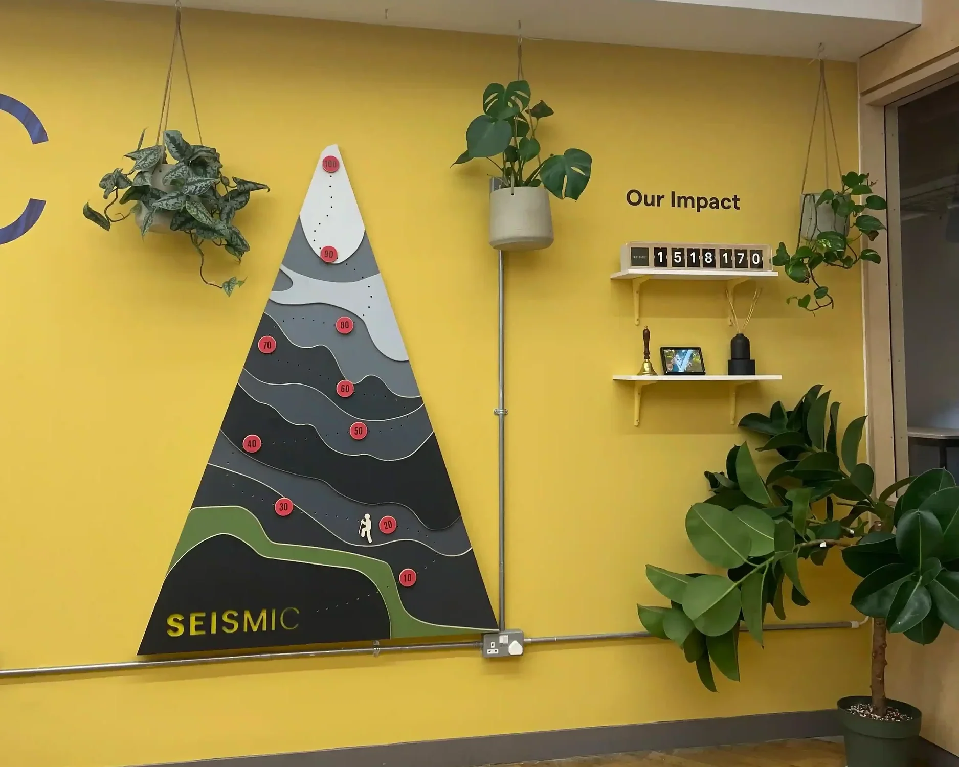 Overhead view of Seismic bespoke office brand installation with yellow feature wall and triangular mountain graphic display