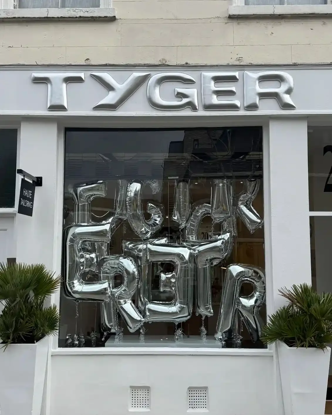 Tyger pop-up store brand activation with silver foil balloon window display, chrome signage and potted plants on London shopfront