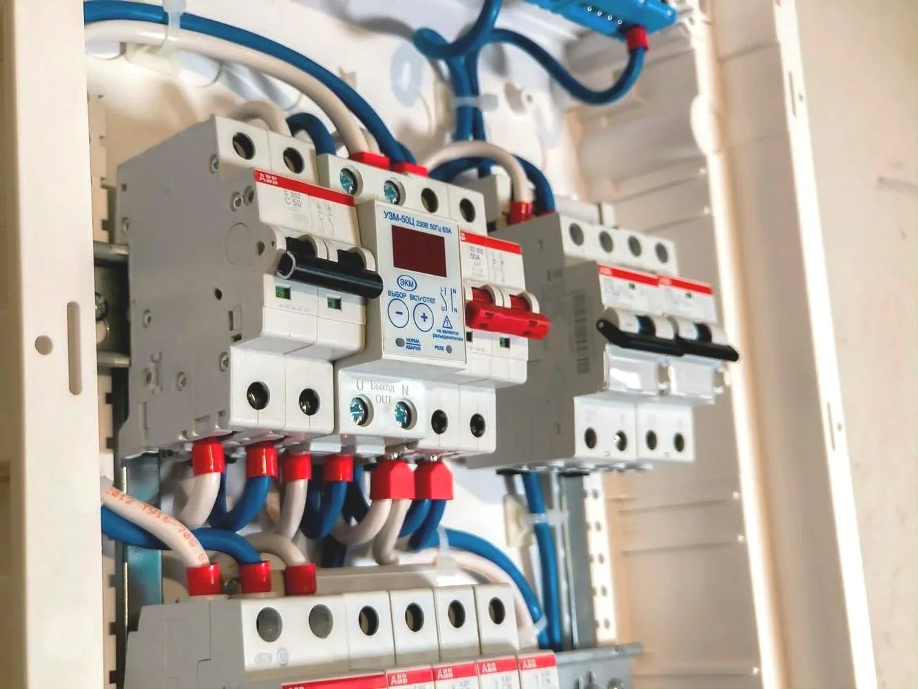 Electrical breaker panel with multiple circuit breakers and wiring.