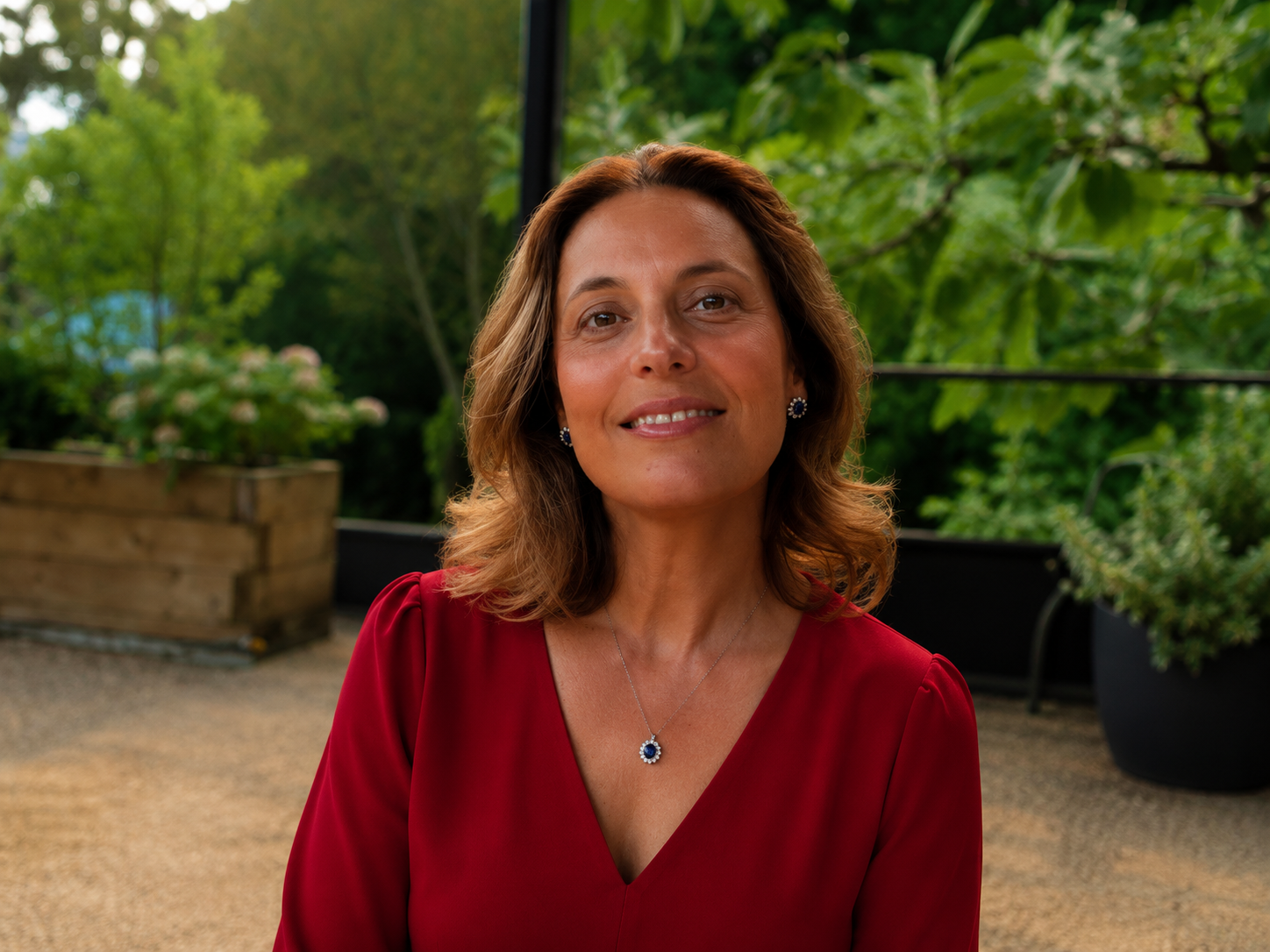 Lourdes Marinetto sitting outdoors in a red blouse