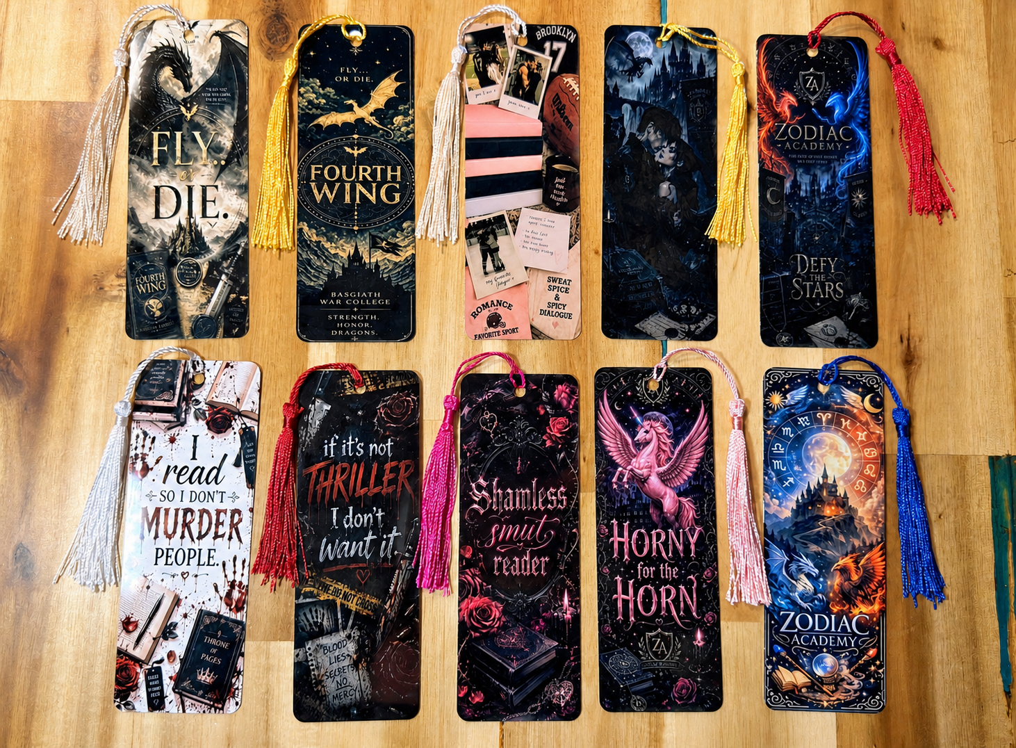 Collection of decorative bookmarks with fantasy and thriller themes displayed on a wooden surface.