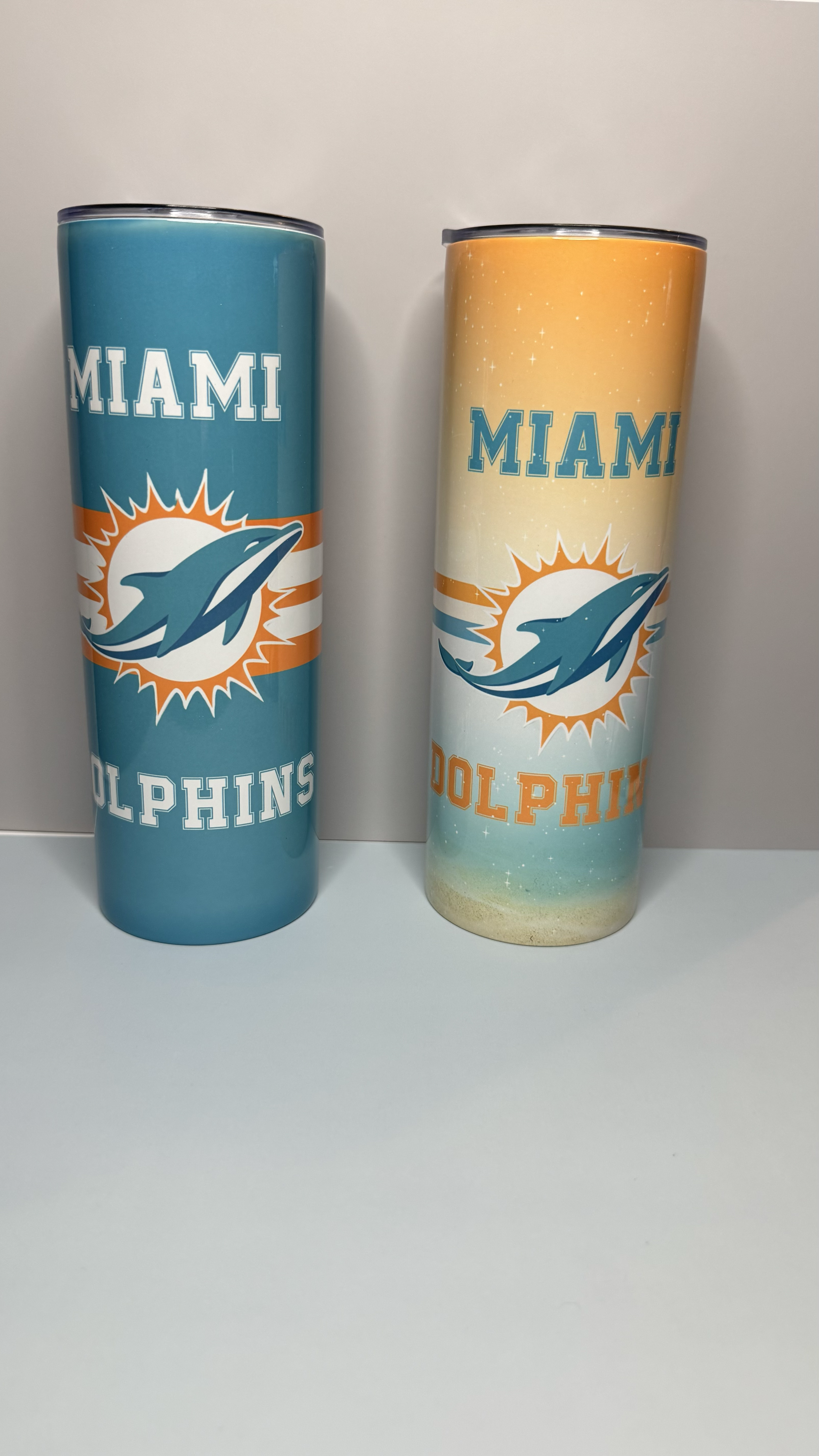 Two tall drink cups with multiple colors and the Miami Dolphins logo.