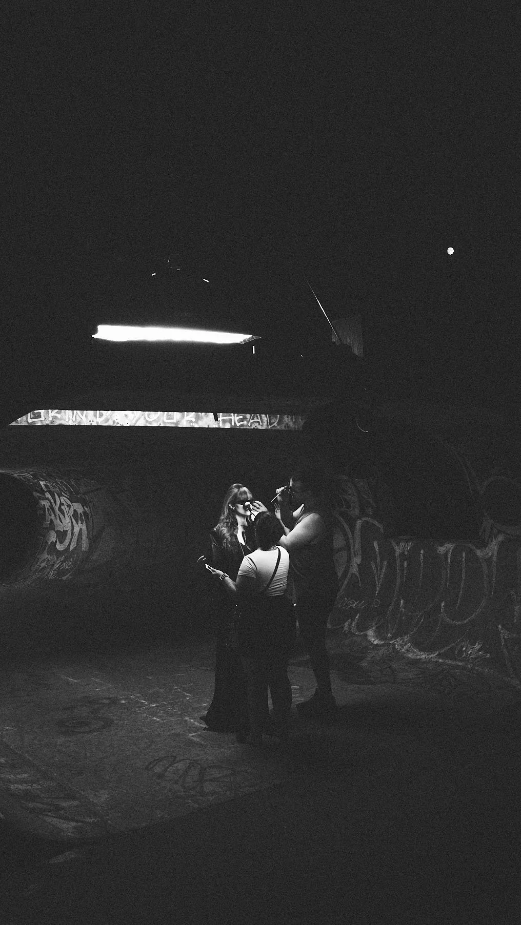 Behind the scenes on a night shoot in a graffiti covered skate park tunnel