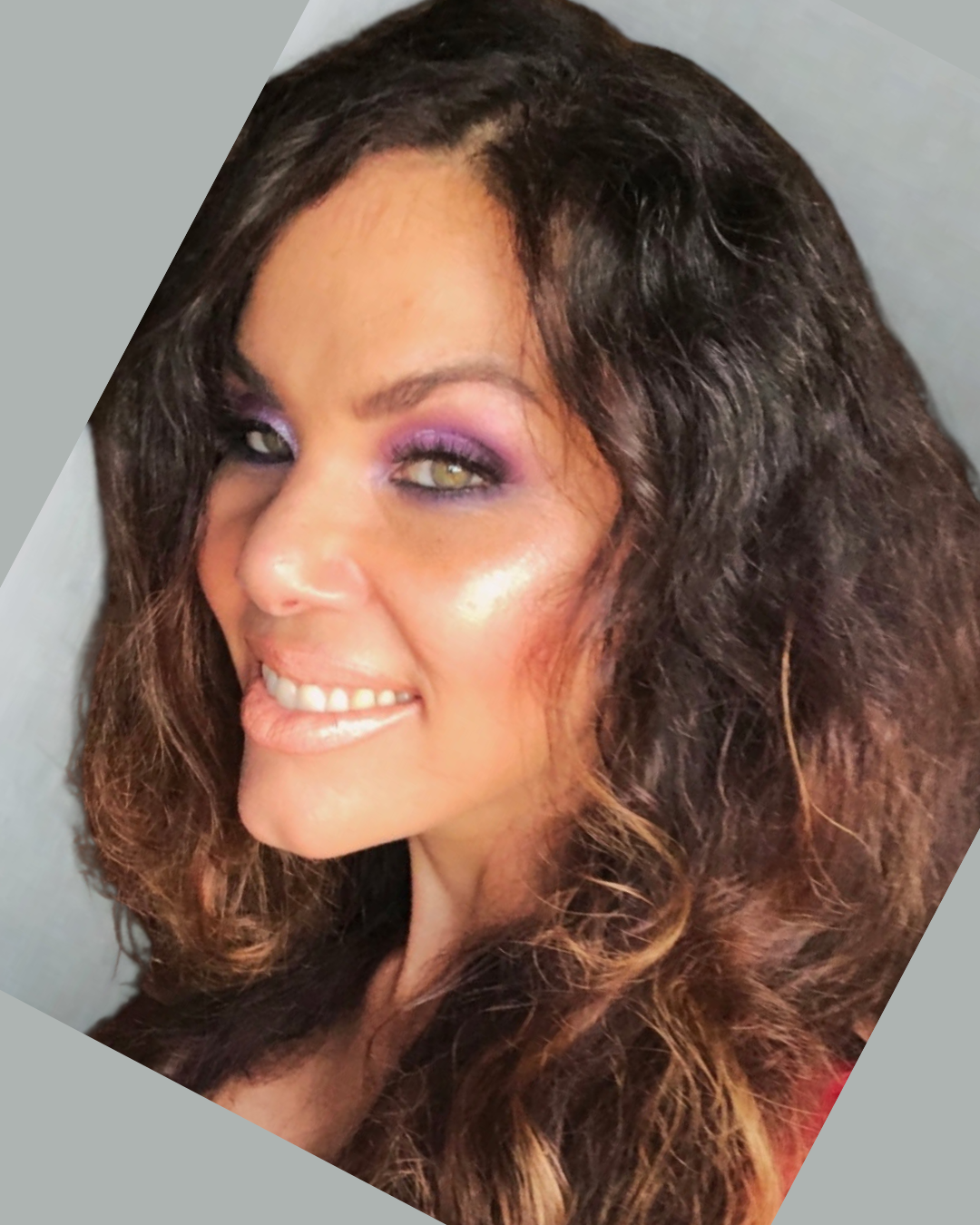 Chef Wayne G. Hooker Scholarship Board Member A woman with long, wavy dark hair and purple eye makeup smiling at the camera.