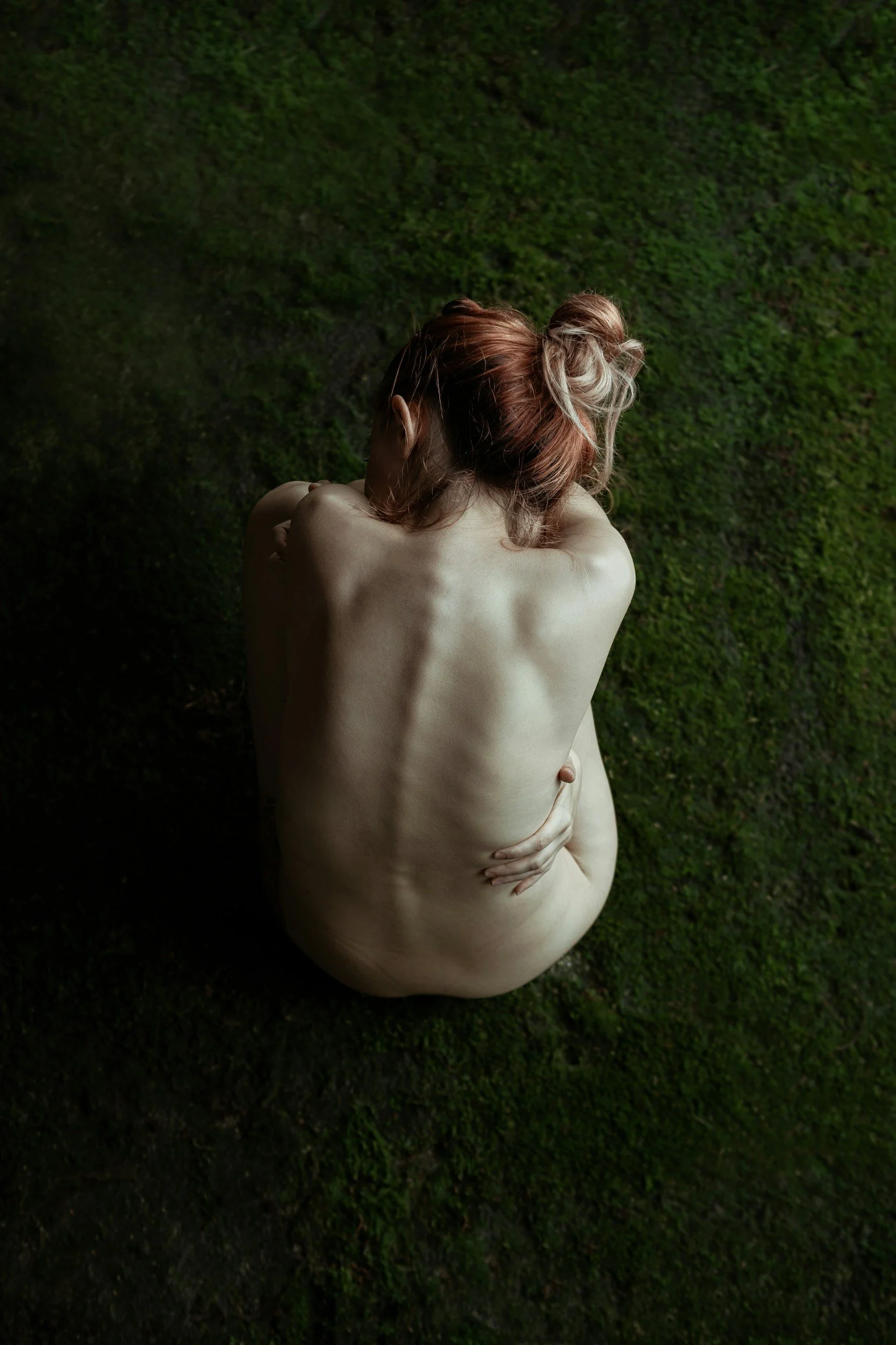 Femme assise de dos sur un tapis de mousse