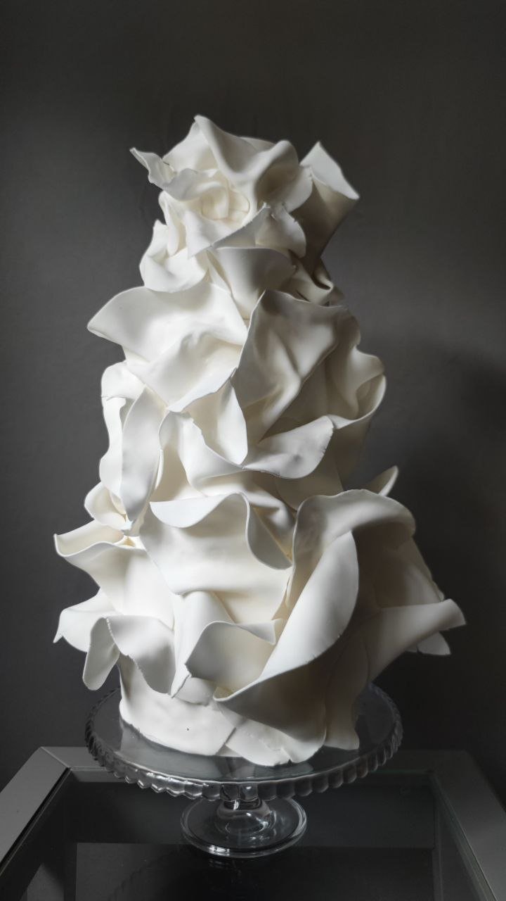 Luxury white wedding cake with an artistic sculptural finish, designed as a modern statement cake.