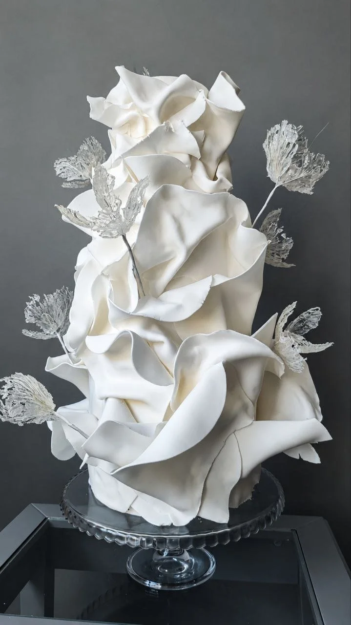 White sculptural wedding cake decorated with beautiful crystal flowers, a contemporary luxury wedding cake design