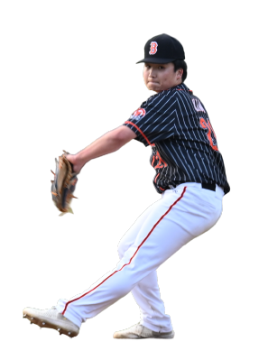 Young boy in baseball uniform pitching a ball, wearing a black cap with a red 'B' logo, and white pants with red and navy stripes.