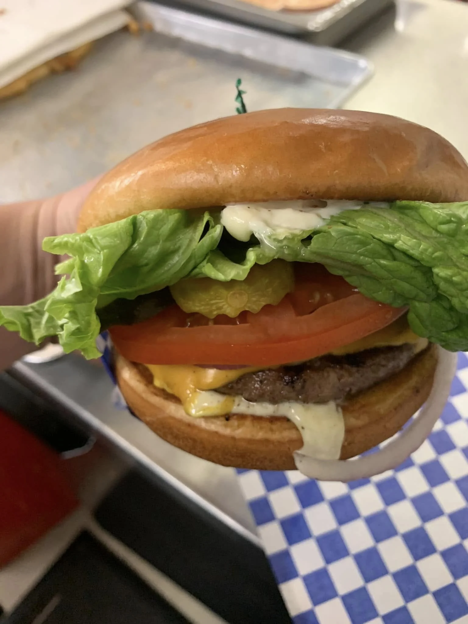 A close-up of a cheeseburger with lettuce, tomato, cheese, and a beef patty in a bun.