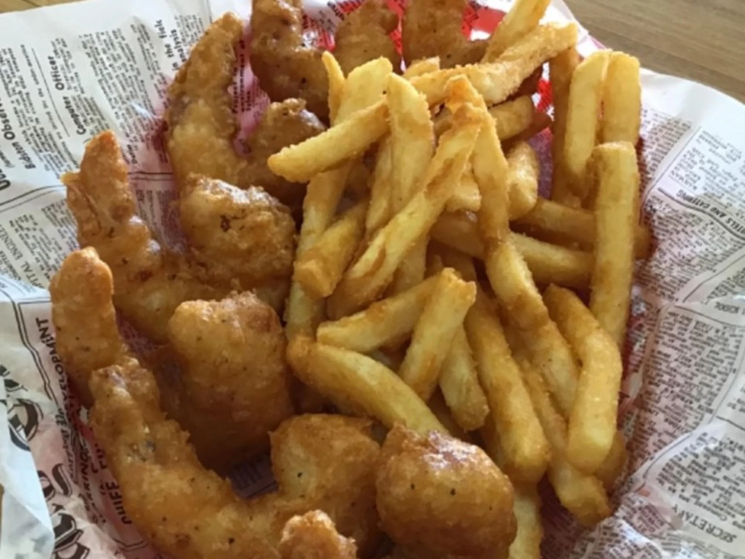 Fried fish and French fries on newspaper