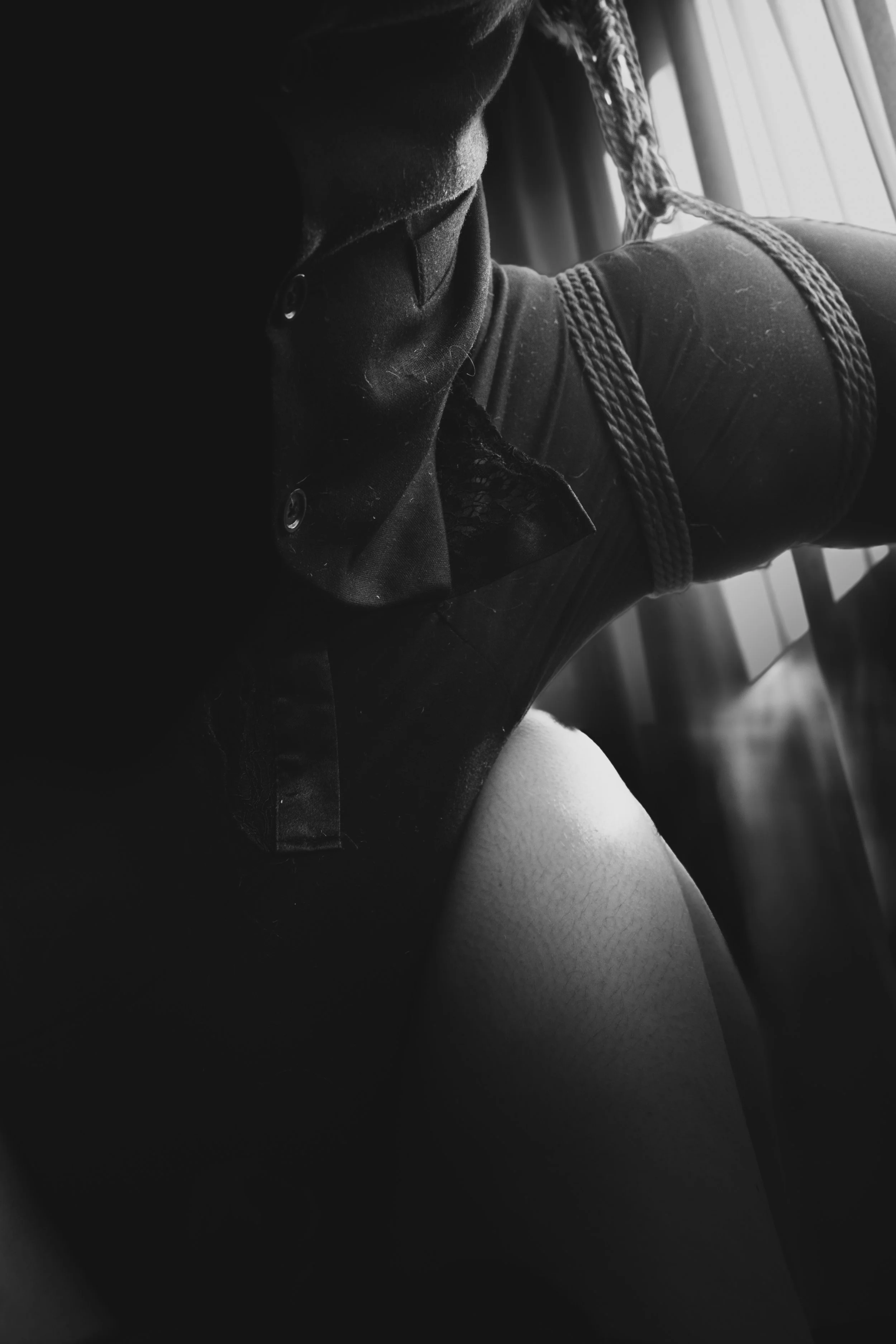 Black and white photo of a person's legs during a rope scene