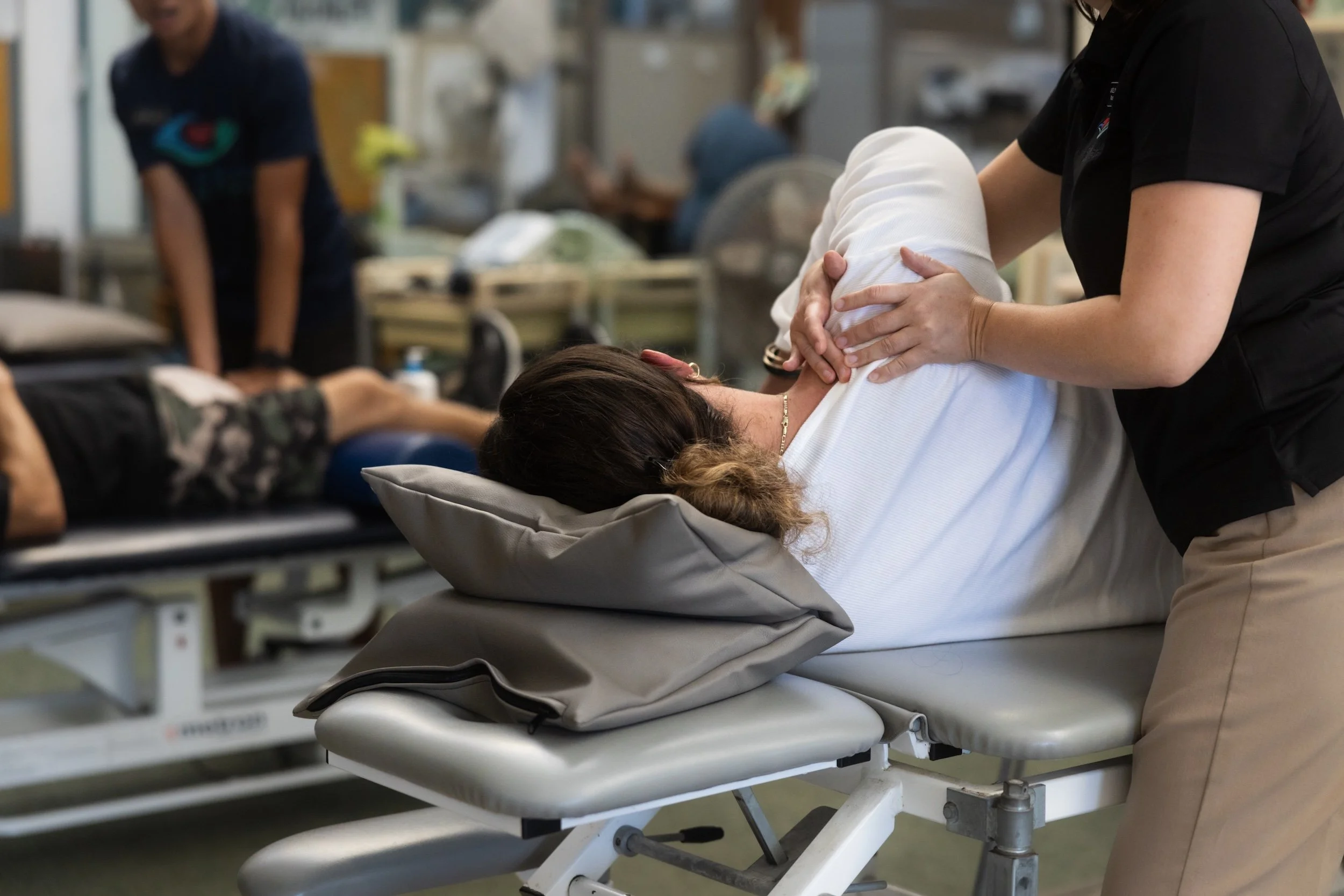 A Fukuji & Lum physical therapist performs hands-on manual therapy during a treatment session.