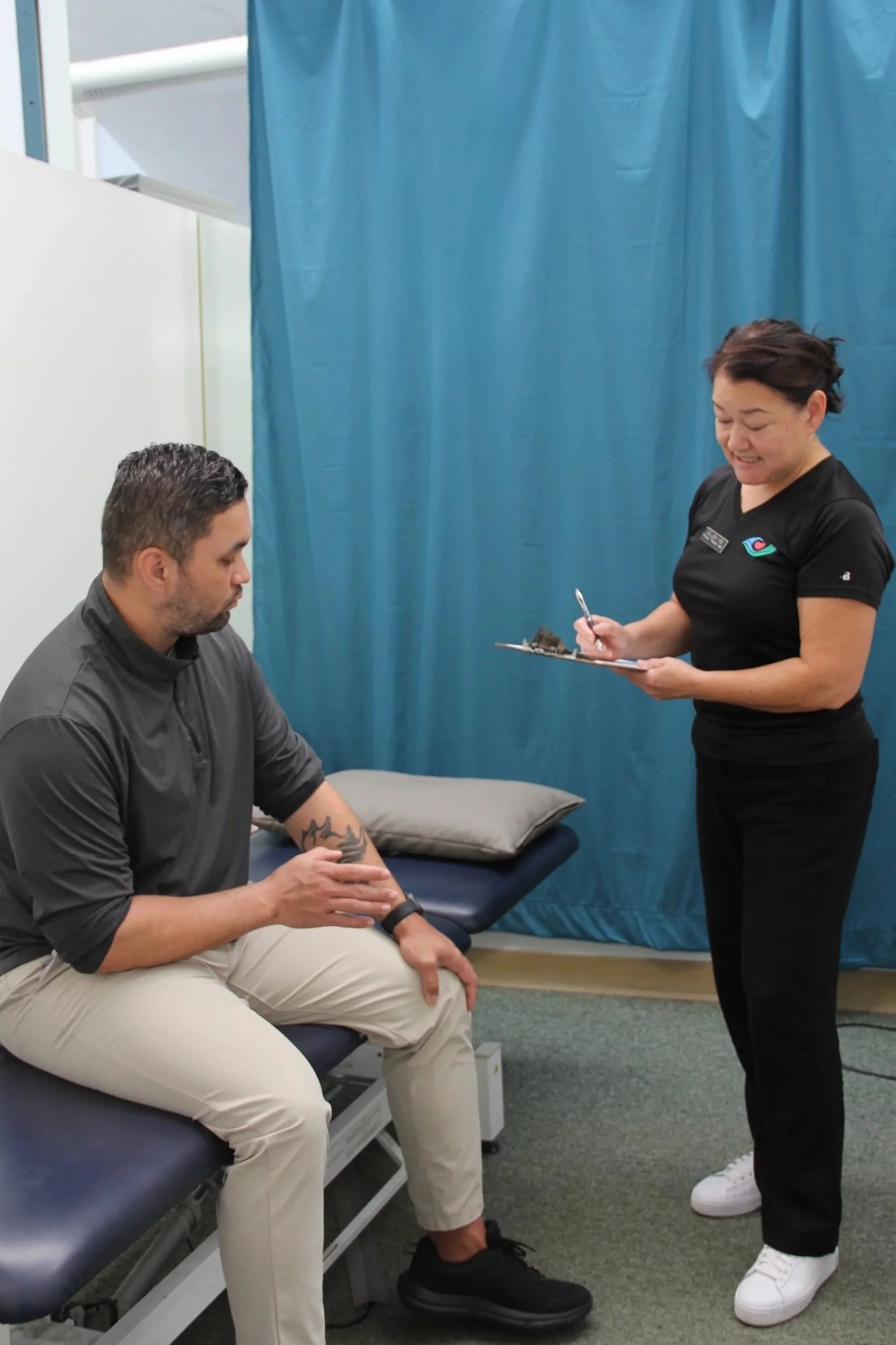A physical therapist warmly greets a patient at the start of their visit.