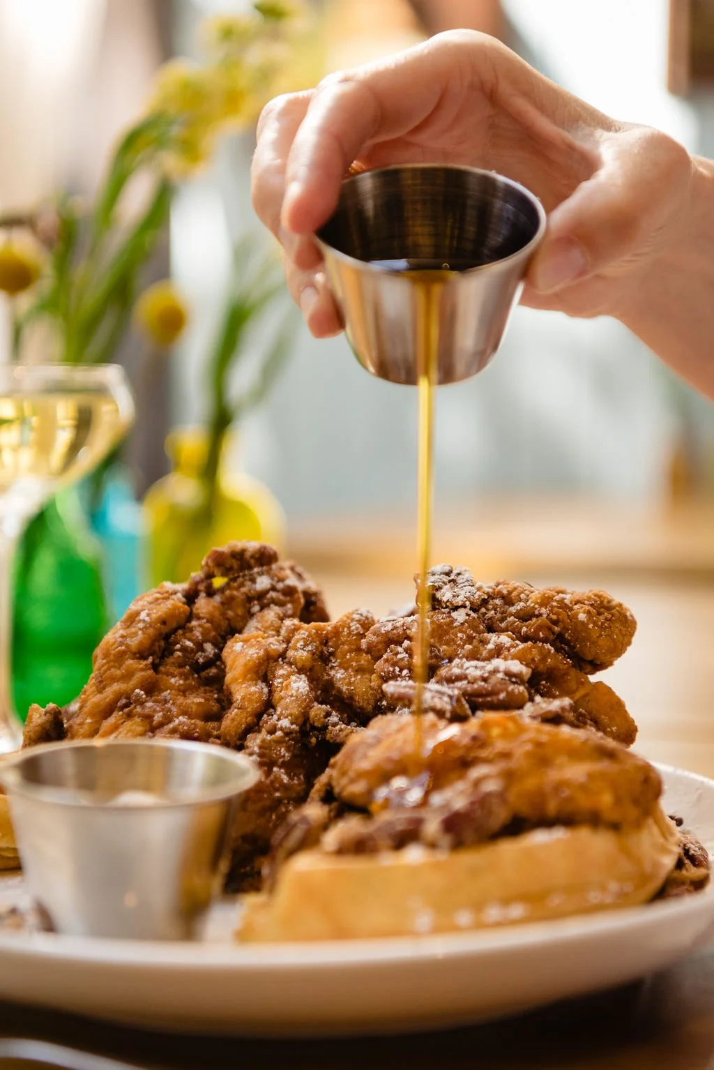  Syrup being poured on chicken and waffles 