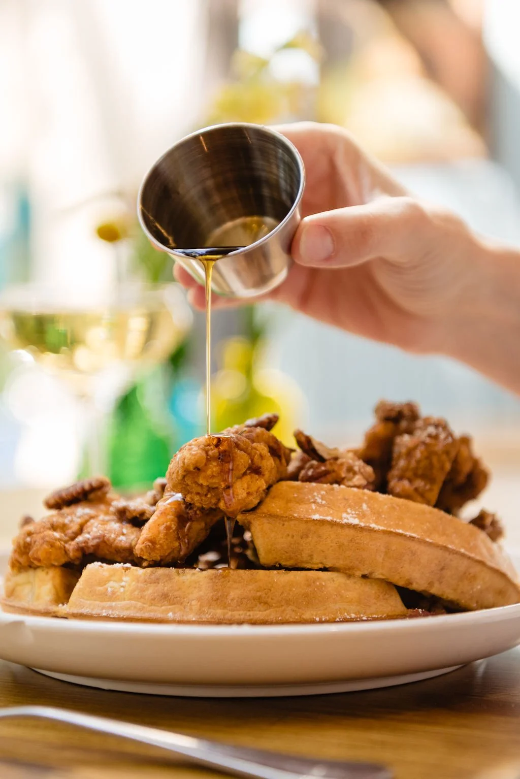  Syrup being poured over chicken and waffles 