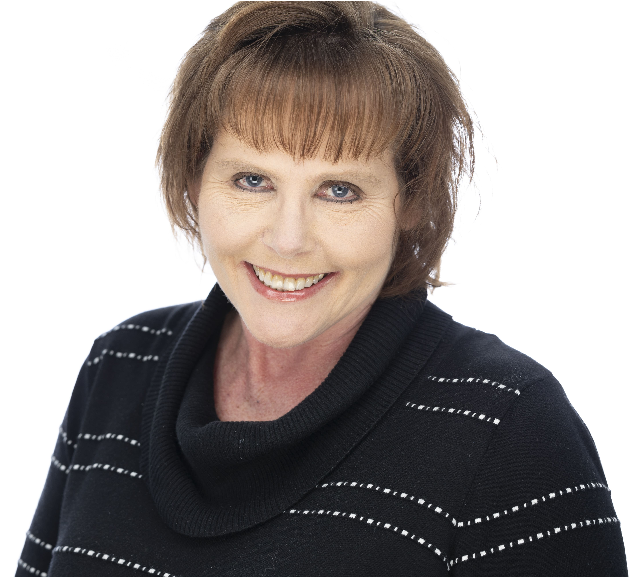 Close-up of a smiling woman with short brown hair, blue eyes, and light skin, wearing a black sweater with white stitching details.