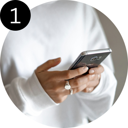 Person holding a smartphone with a white sleeve and a ring on their finger
