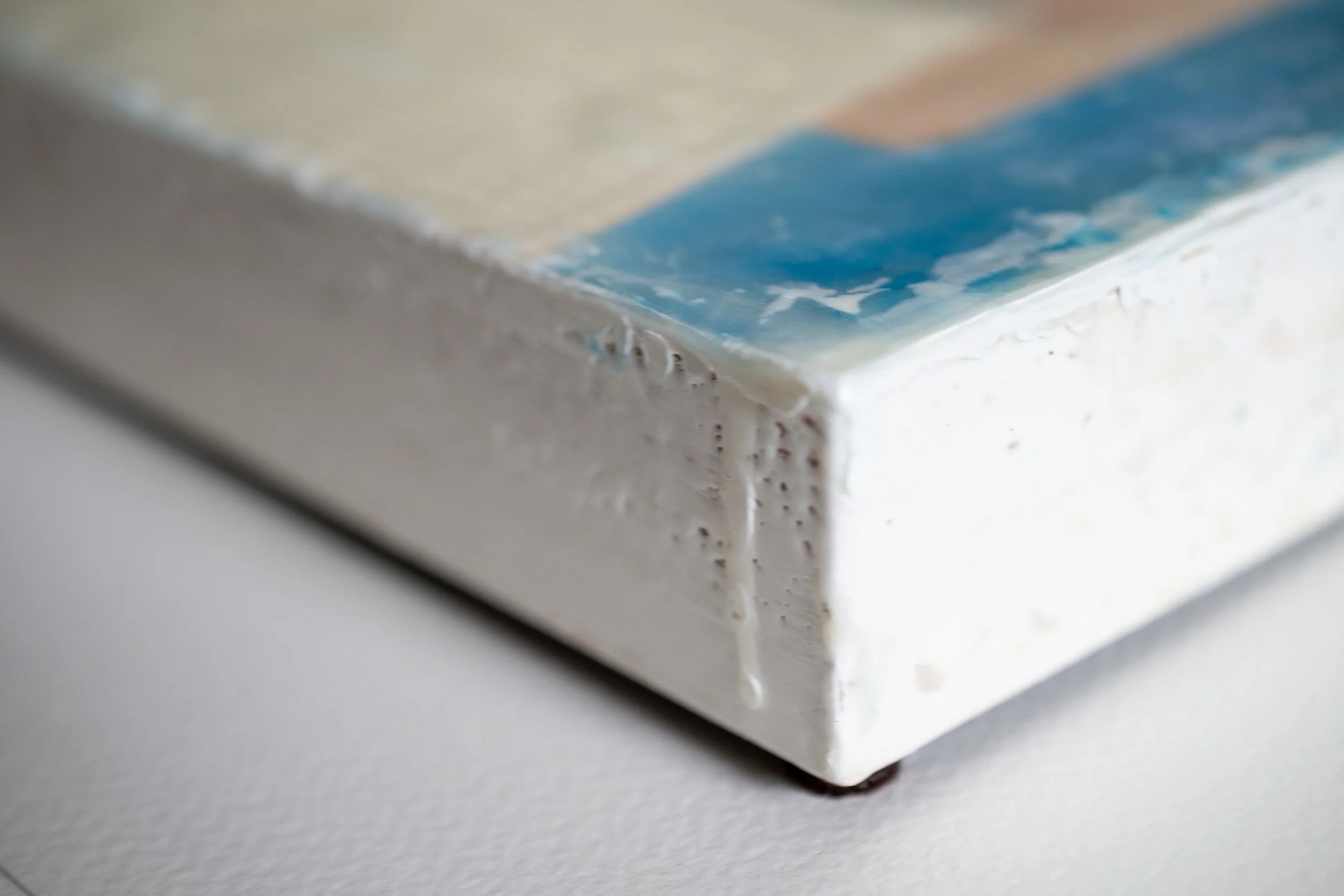 Close-up of a corner of encaustic artwork demonstrating texture of the medium, as part of artwork.