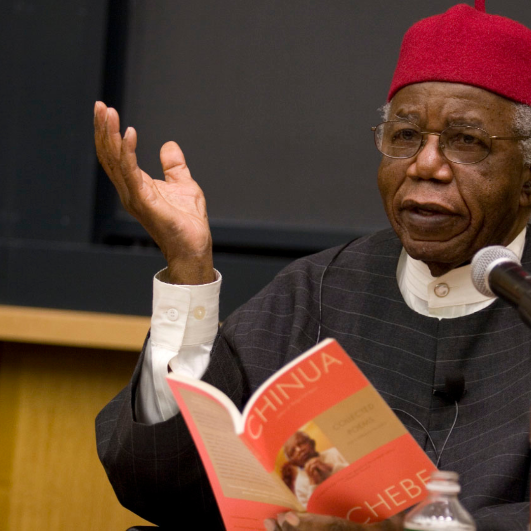 Image of Chinua Achebe holding a book