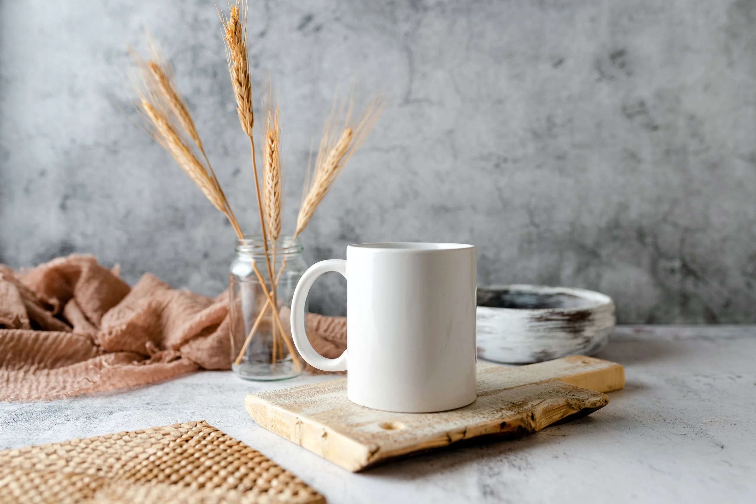 Coffee mug with wheat in a jar in background