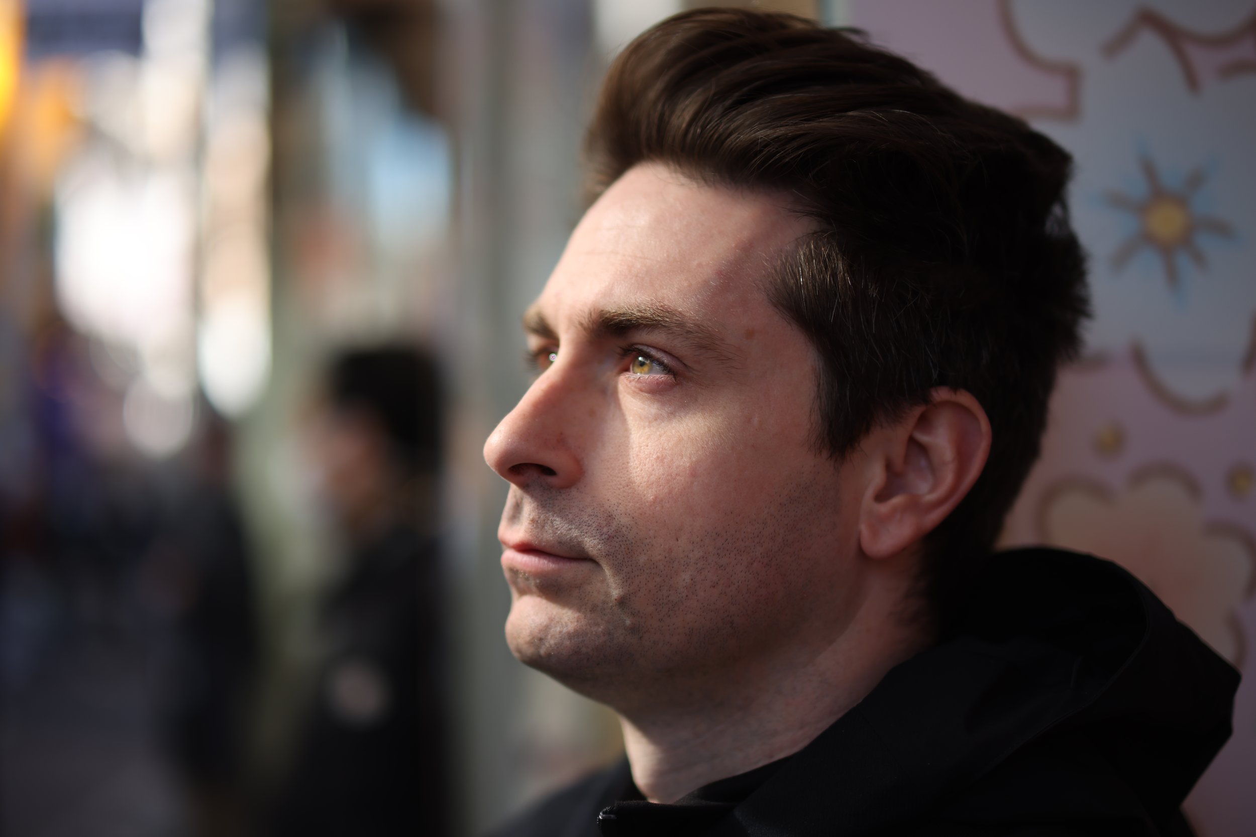 Close-up of a young man's face looking to the left, with well-groomed dark hair and light skin. Blurred background. Portrait photography. Lifestyle. Japan. Travel photography.