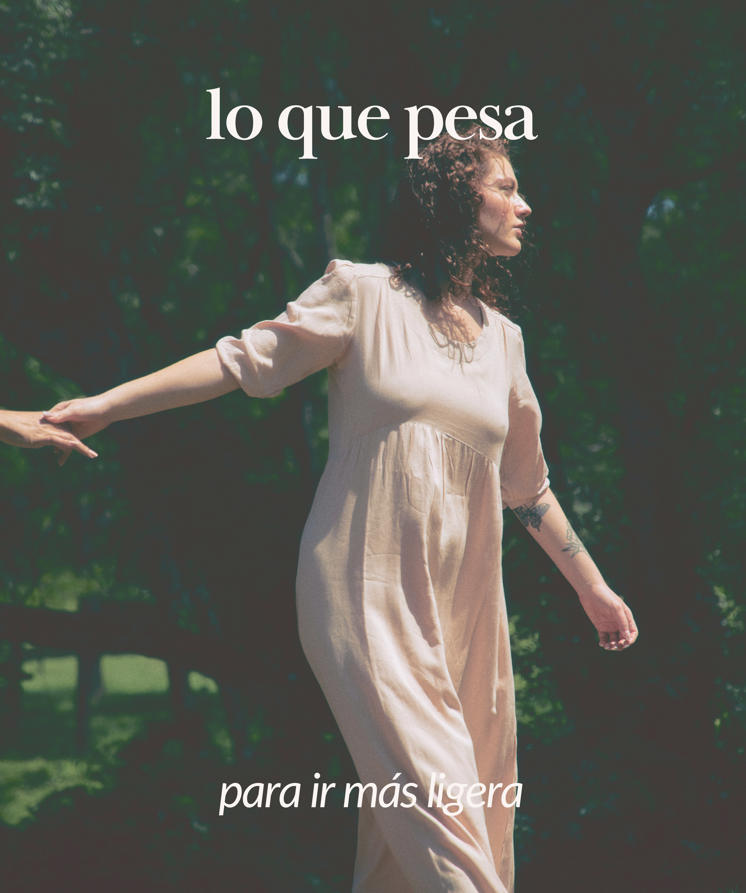 Mujer de pie en un entorno natural con árboles, con los brazos extendidos, usando un vestido beige claro, en un gesto de libertad y ligereza.