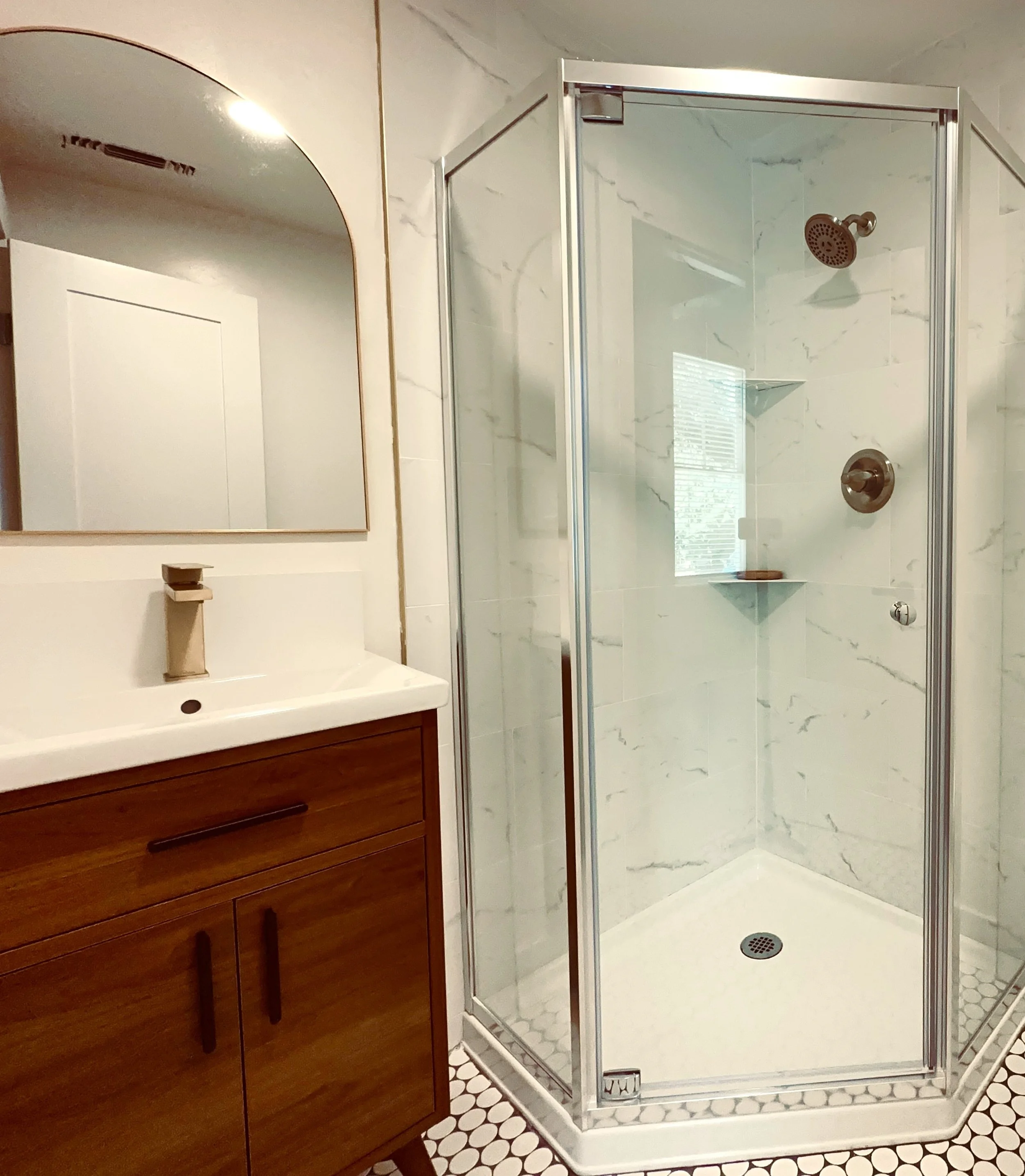 Bathroom remodel by TRI Construction Sacramento — walk-in shower with marble tile, wood vanity, modern fixtures