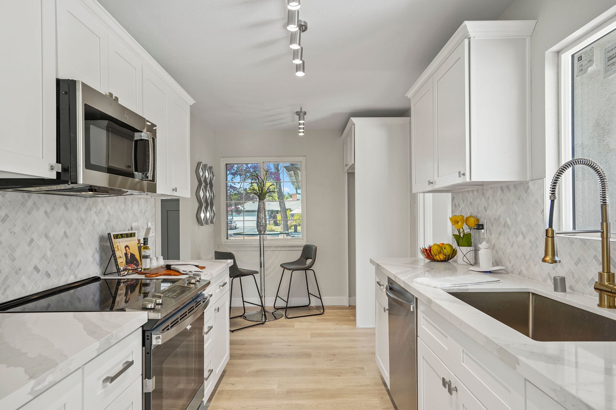 Kitchen remodel by TRI Construction Company Sacramento — white shaker cabinets, stainless appliances, modern lighting