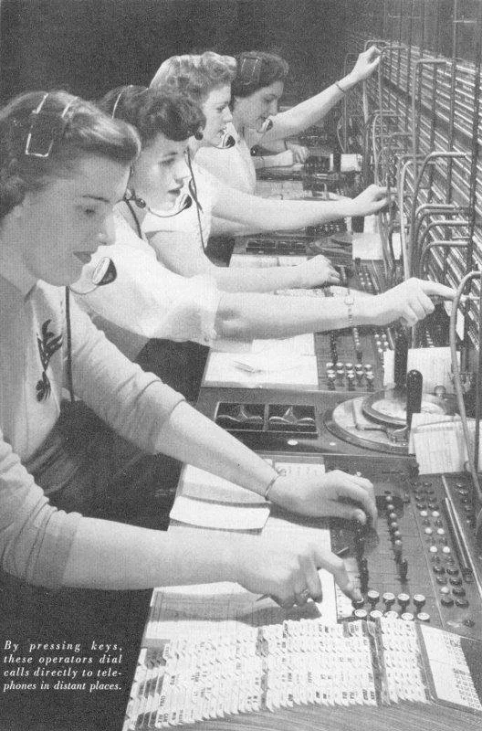 Four women in vintage attire working at a radio station control panel with dials and switches, wearing headsets, and operating communication equipment.