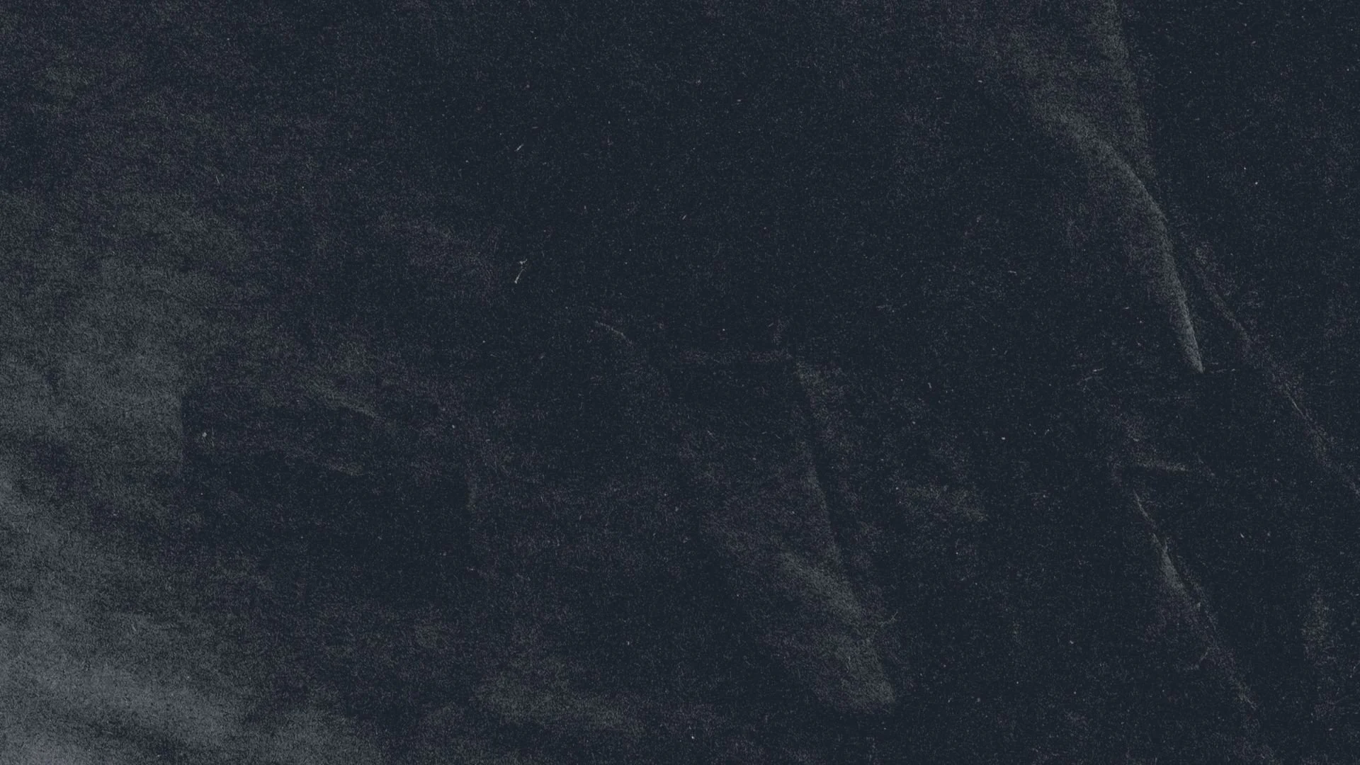 Close-up of a dark, textured surface with subtle lighter streaks and speckles.