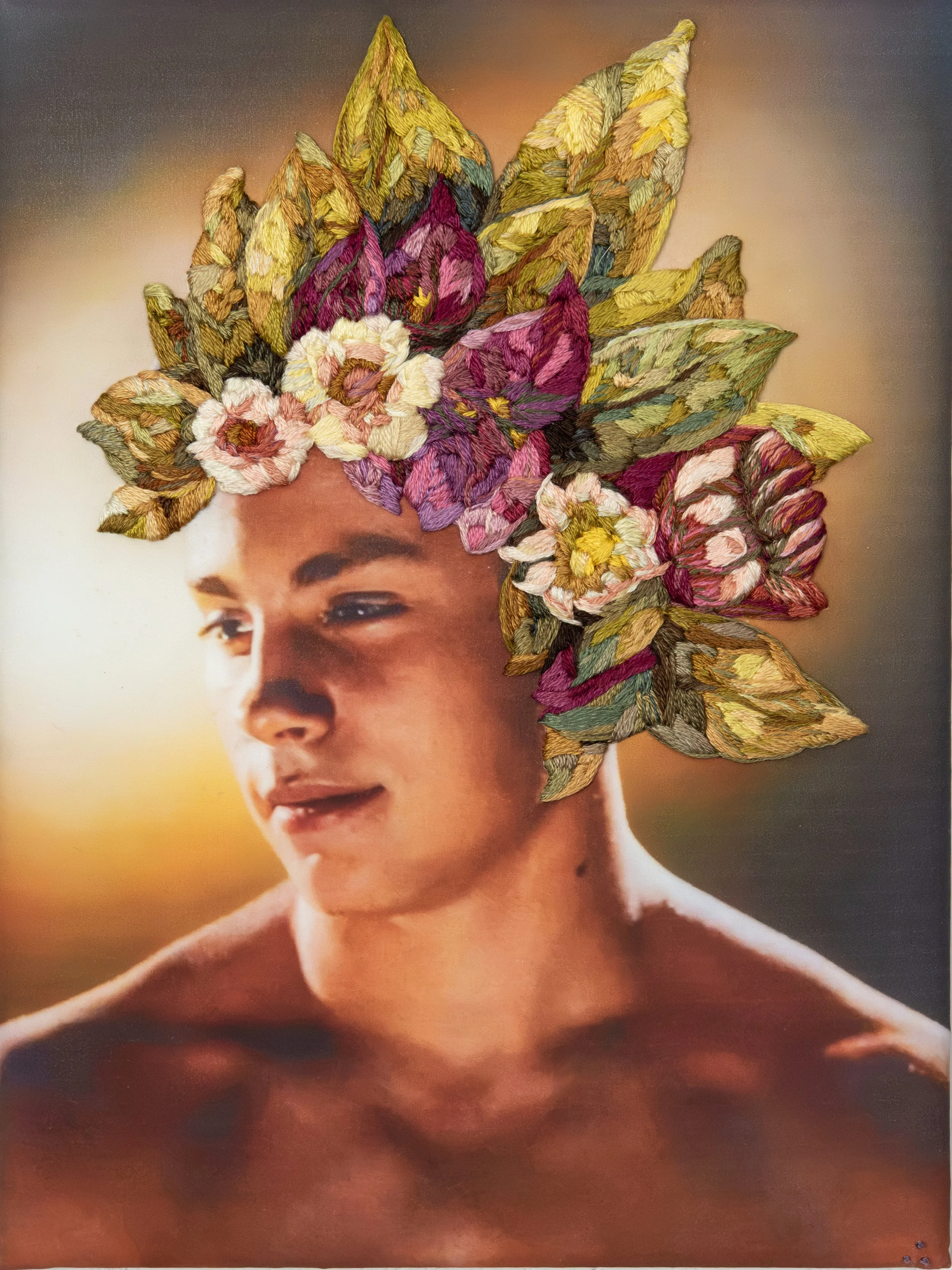 Profile of young man in vintage photograph my Bob Mizer. On his head is an embroidered crown of flowers and leaves. The image has a coded expression of love and references Frida Kahlo and Sappho.