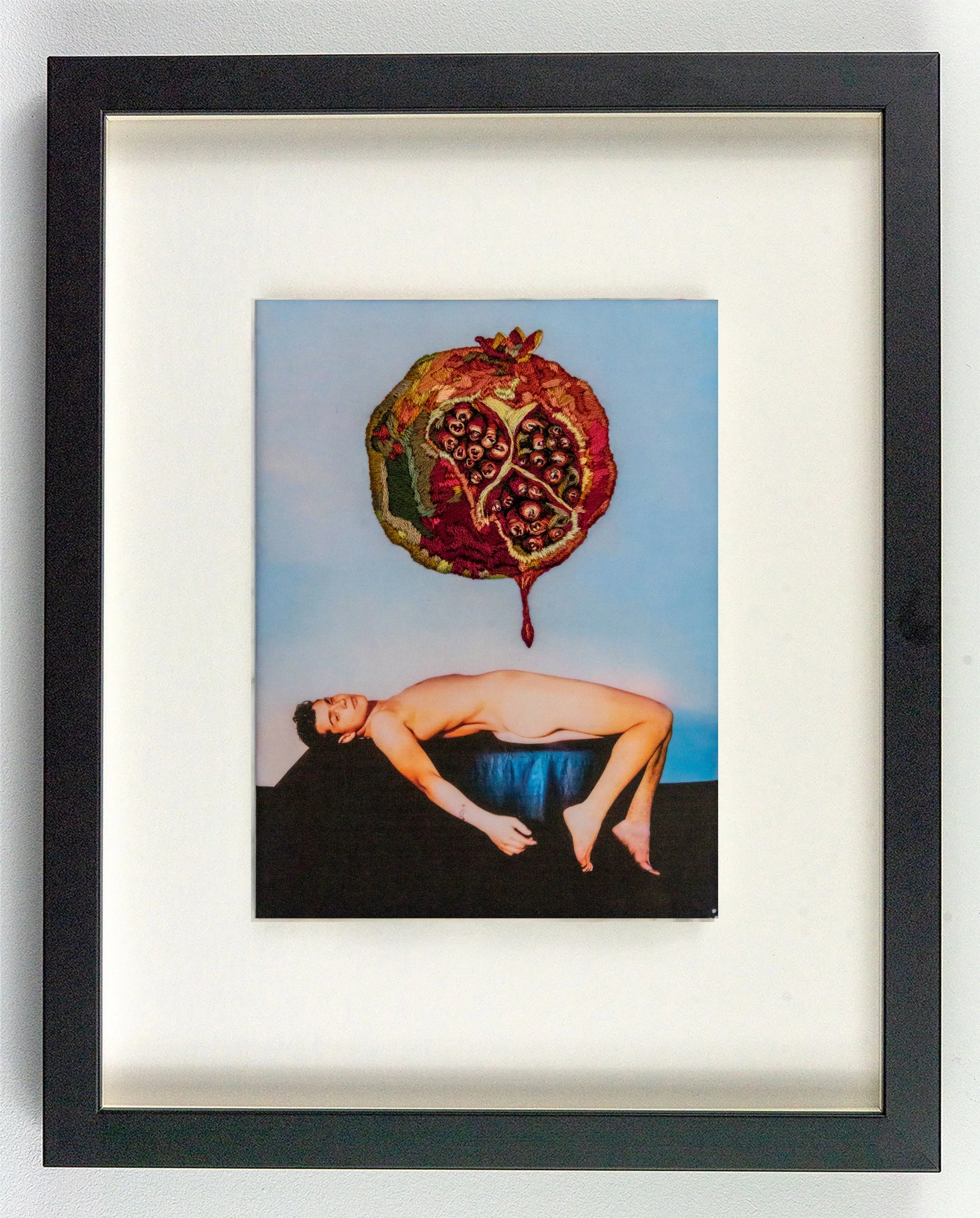 Suspended, embroidered pomegranate on vintage physique photograph, framed.