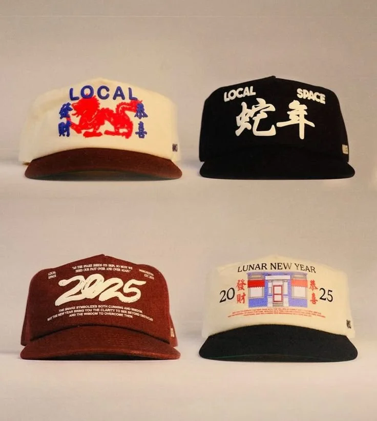 Four caps with different designs and text, arranged in a 2x2 grid on a white surface.