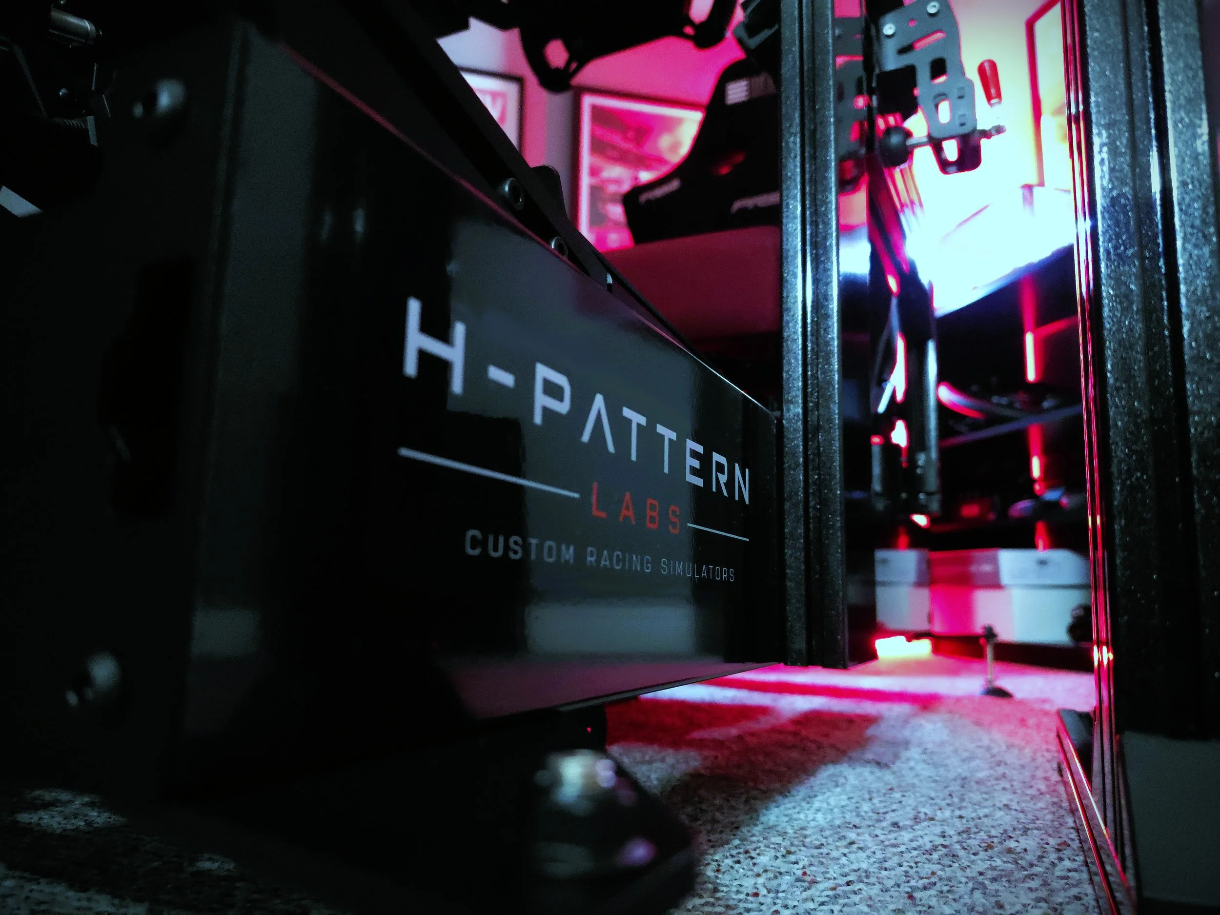 Close-up view of a racing sim-rig, with the H-Pattern Labs logo applied to the chassis.