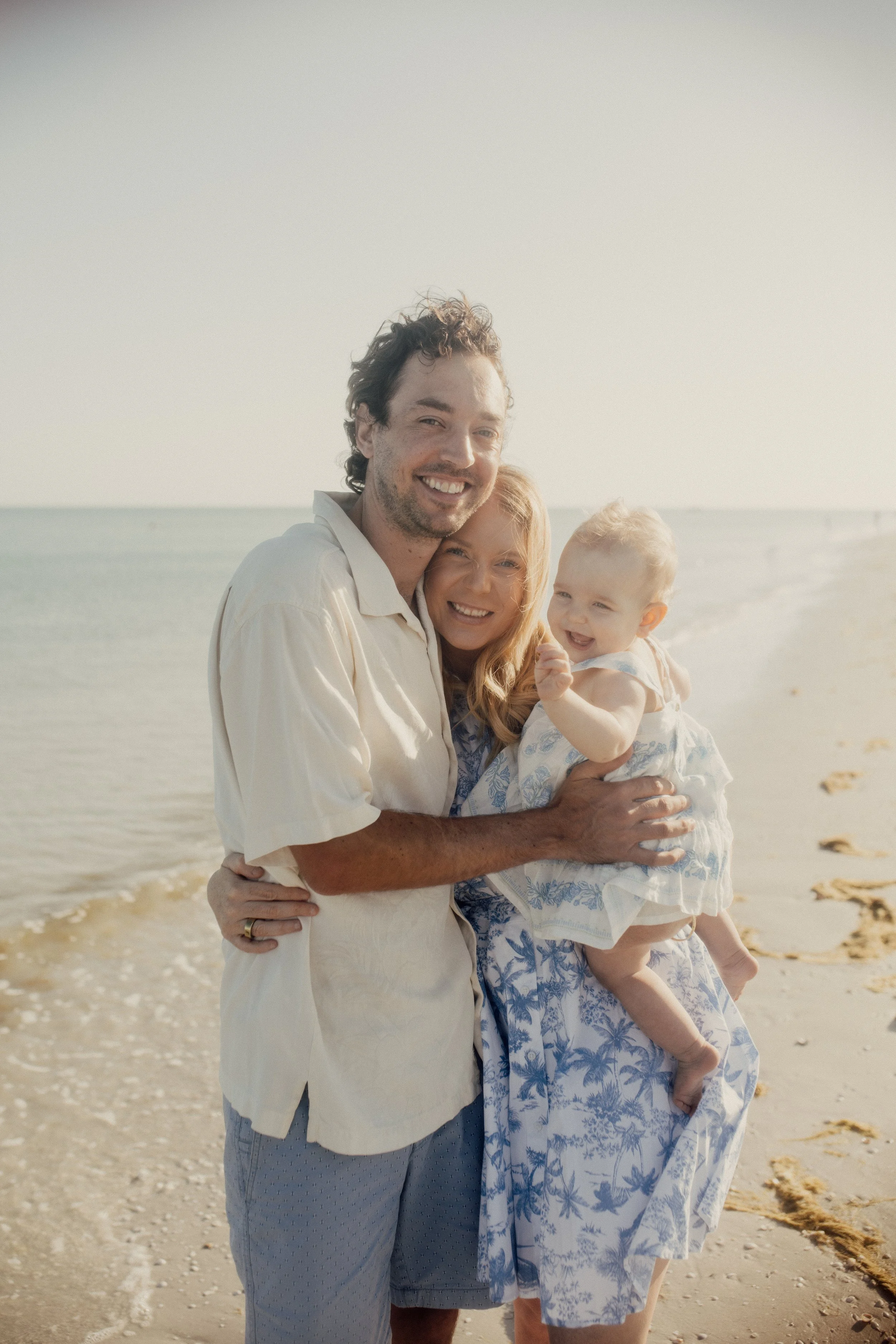 Family therapy and communication-focused lifestyle image of parents and child smiling on a beach by the ocean