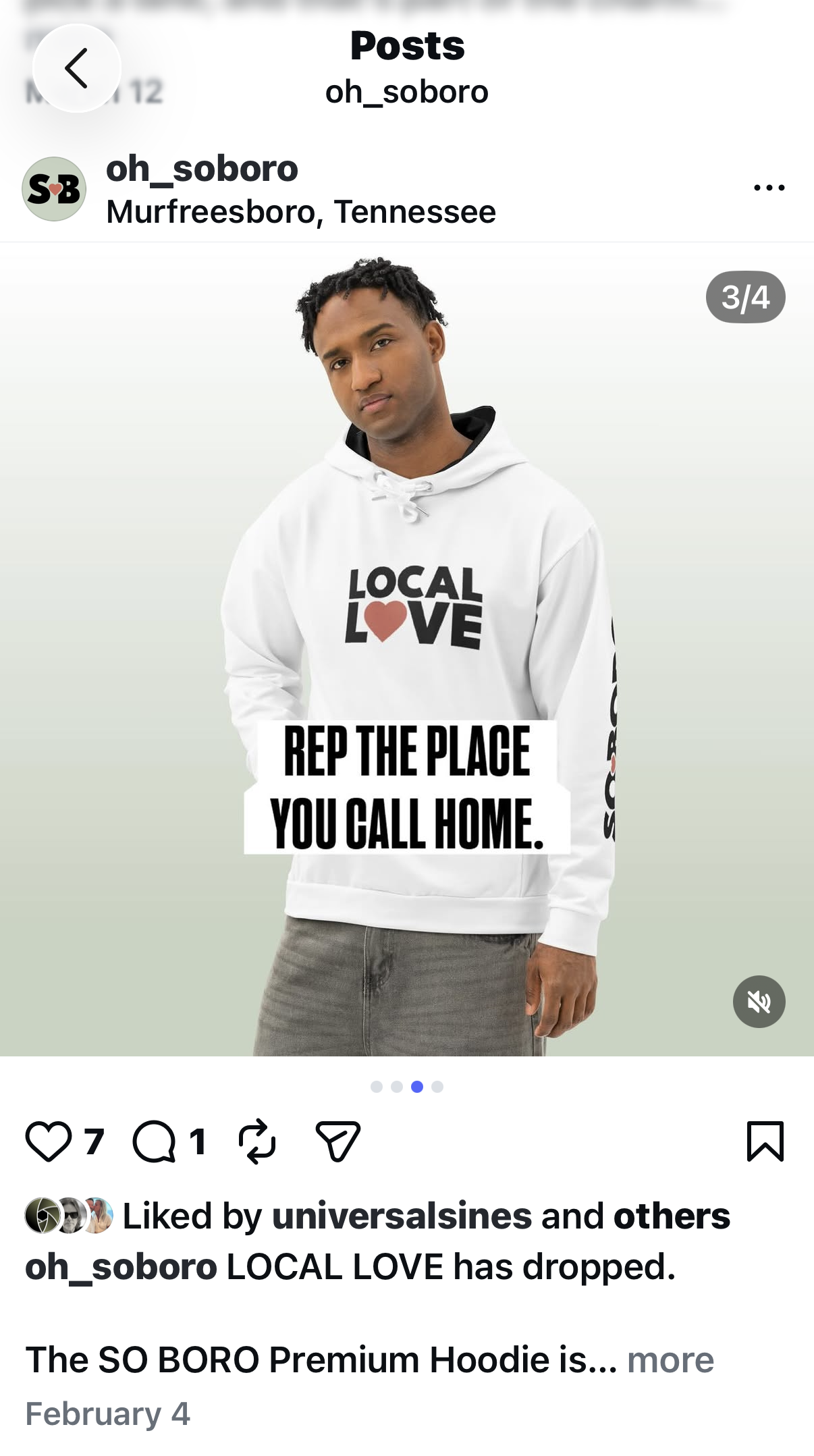 A young man with short curly hair wearing a white hoodie that says "LOCAL LOVE" with a red heart, and a message "REP THE PLACE YOU CALL HOME" in black bold letters, standing against a light background.