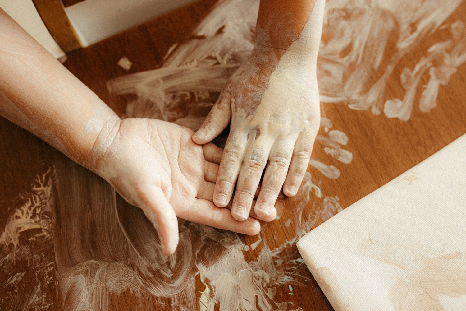 A young child and parent exploring flour with their hands in calm sensory play