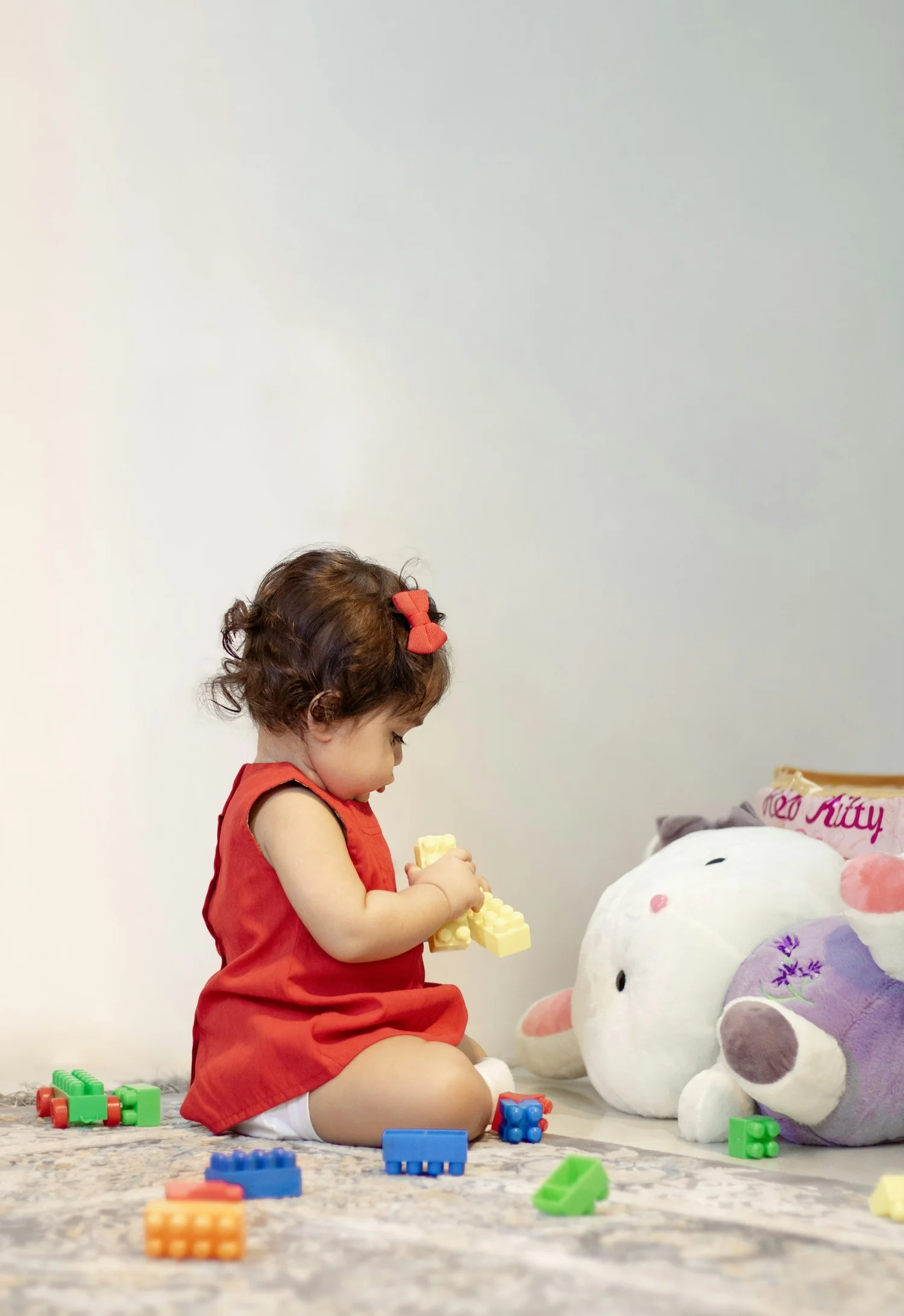 A toddler sitting on the floor playing with blocks