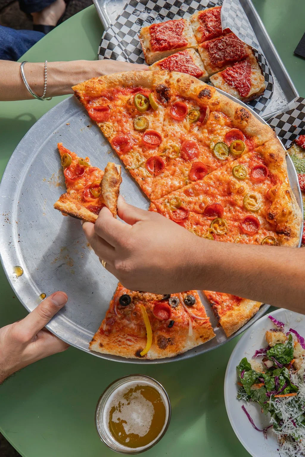 Round pizza close-up: Round Honeycreeper pizza with Grande cheese, pepperoni, pickled jalapenos, Cali vine-ripened tomato sauce, caramelized cheese skirt, finished with Mike's Hot Honey