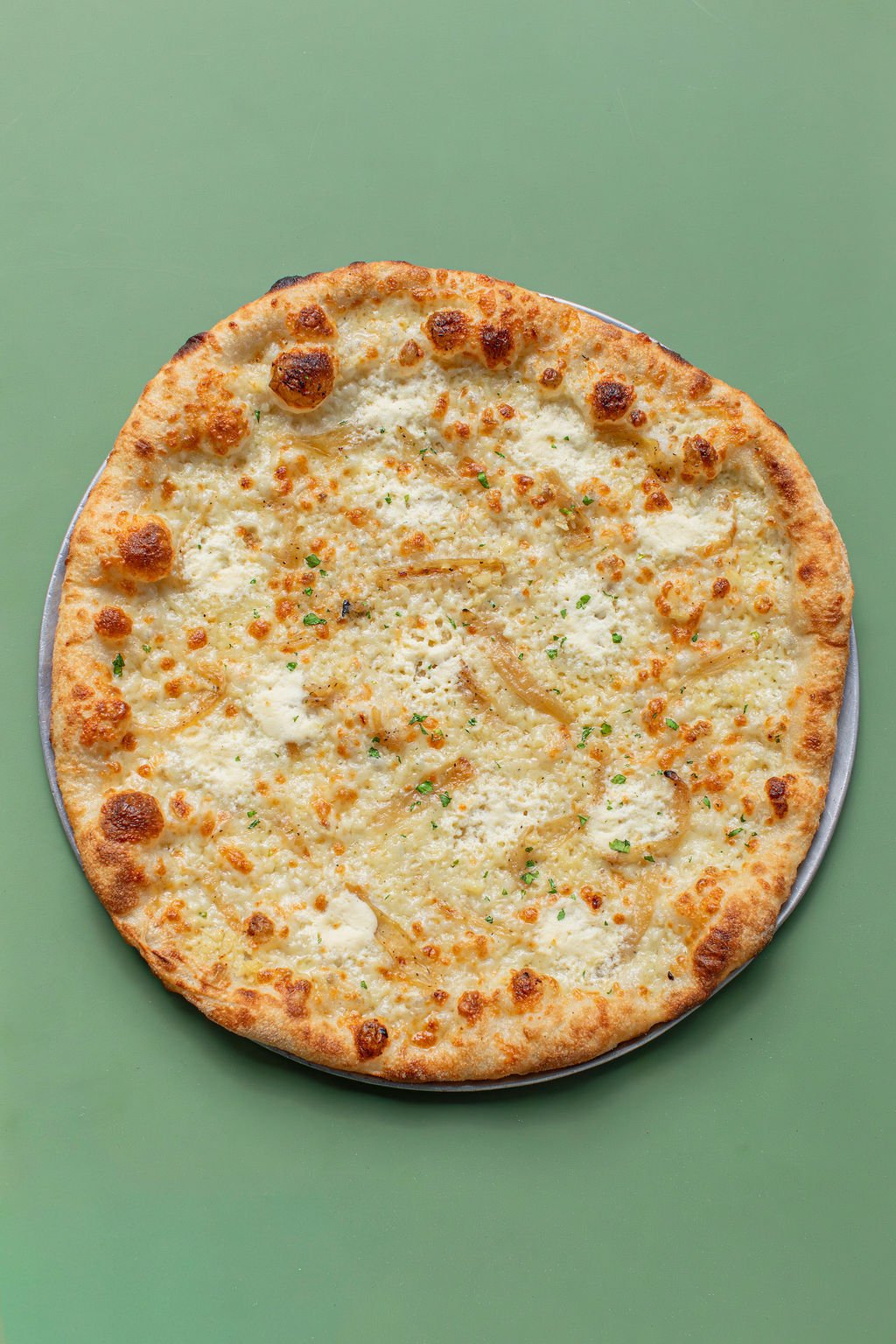 Pizza Mamo garlic bomb round pizza at a outdoor patio table in Honolulu