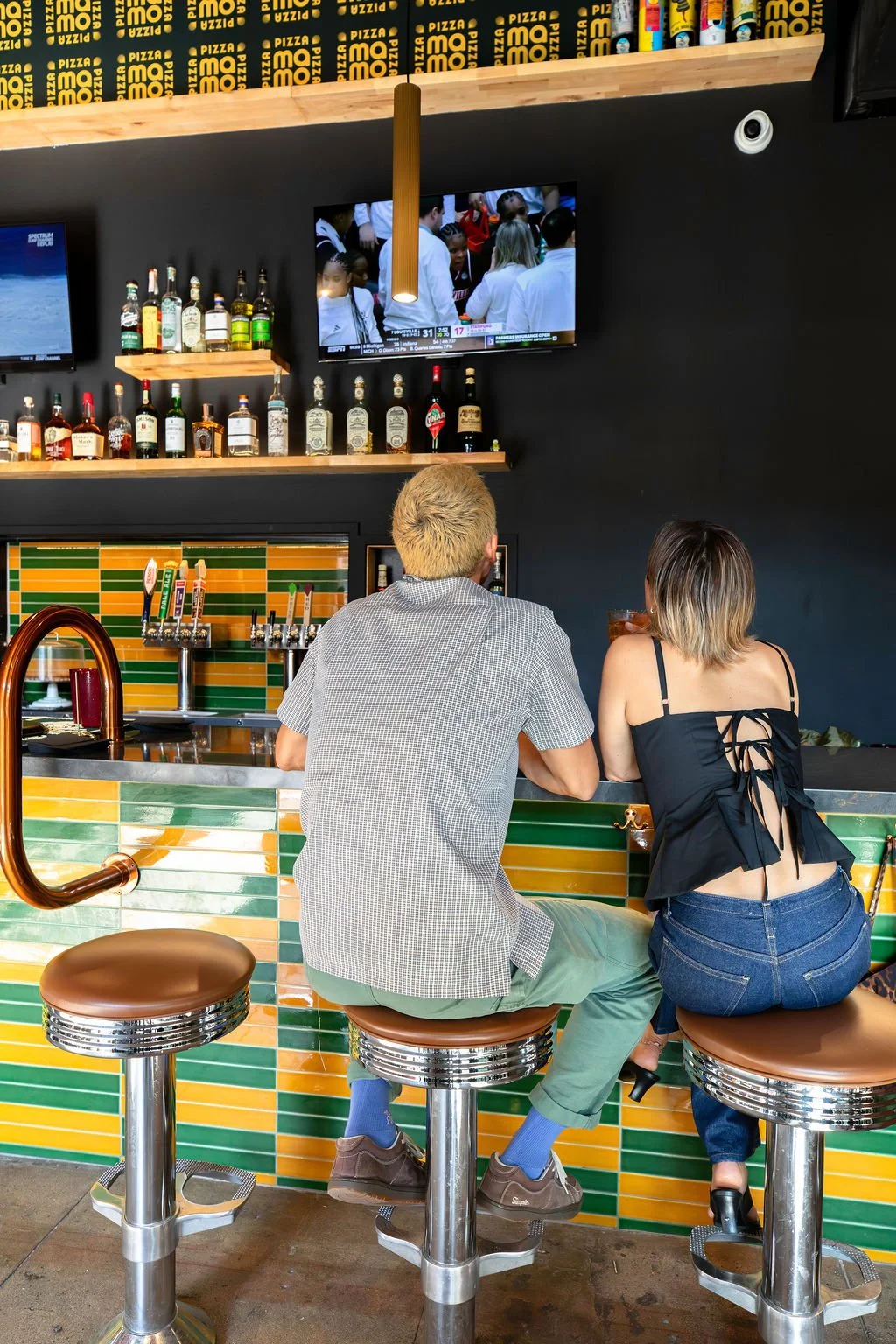 Friends watching the game at the Pizza Mamo full service bar in Chinatown, Honolulu in Waikiki on Oahu